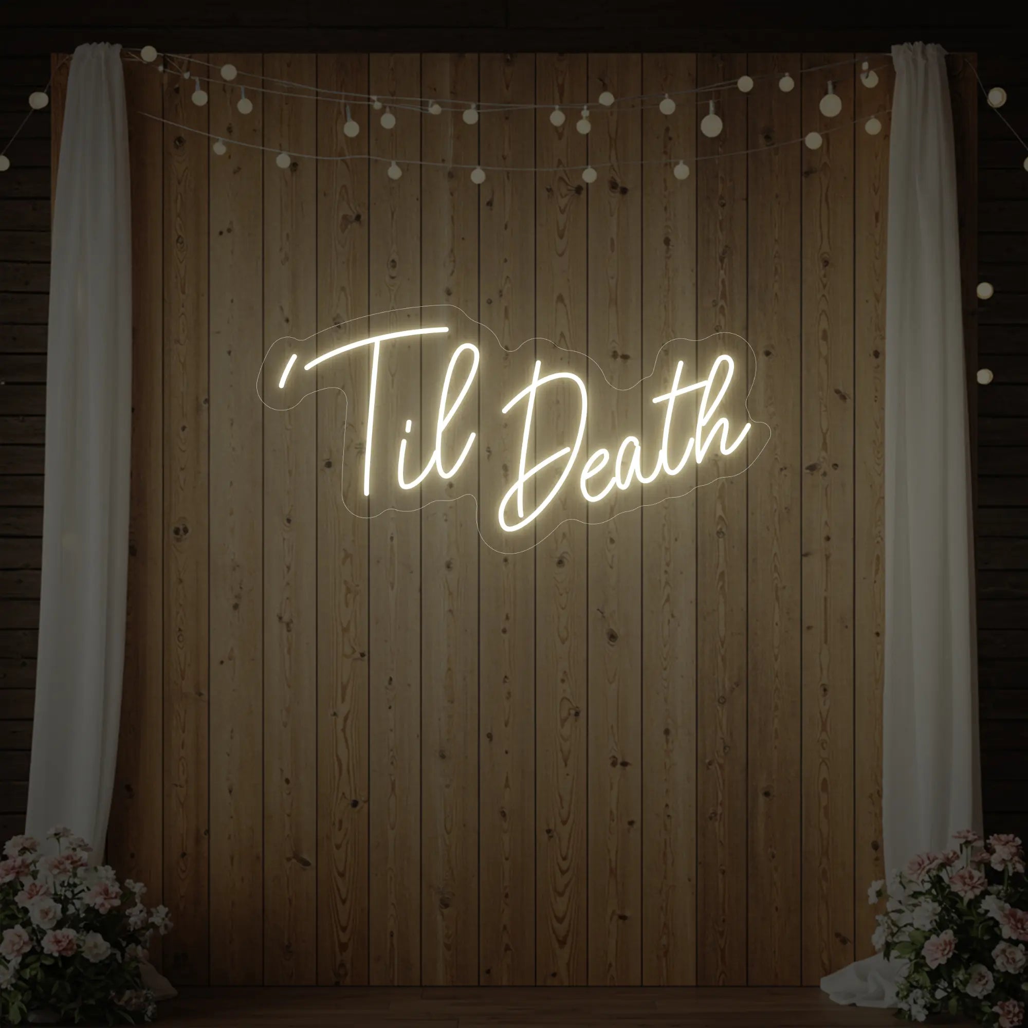''Til Death' neon sign glowing in warm white against a styled interior wall.