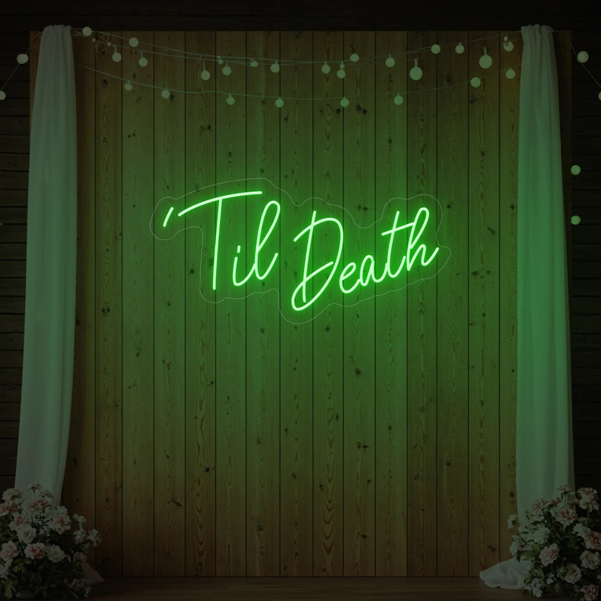 ''Til Death' neon sign glowing in green against a styled interior wall.