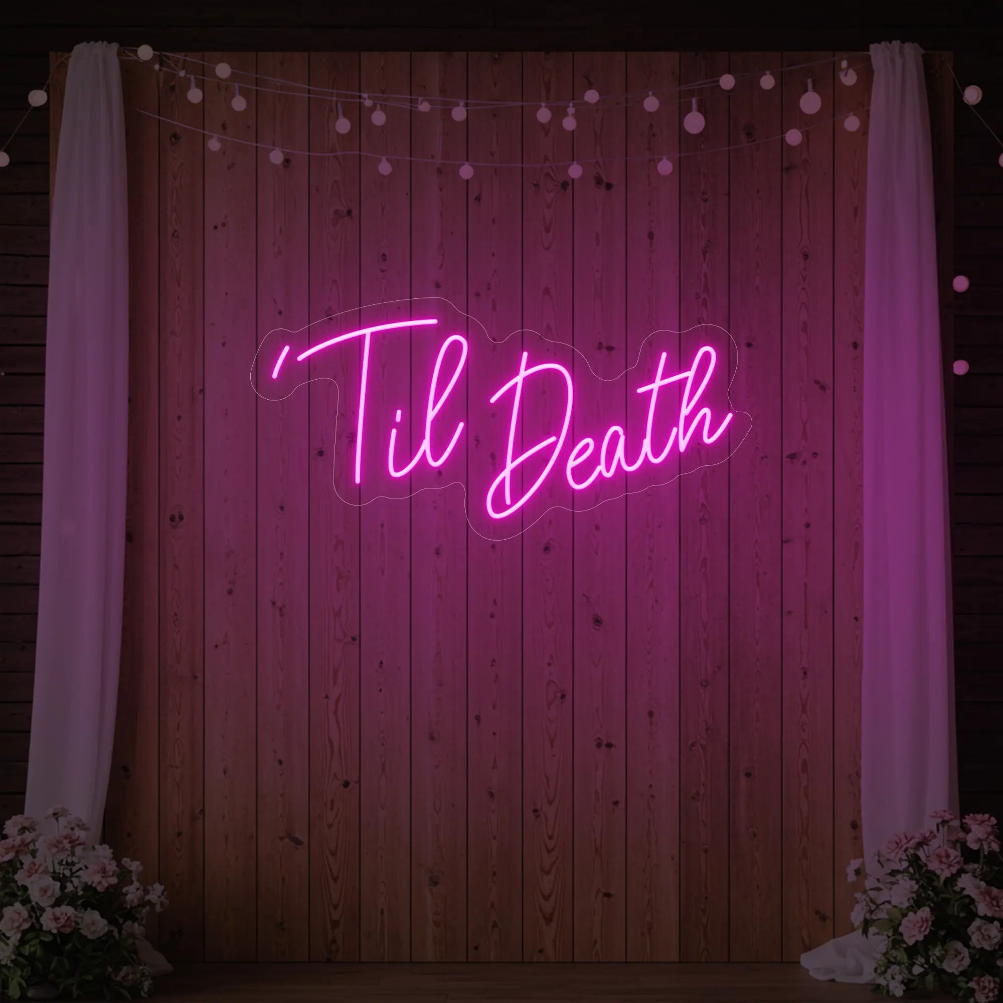 ''Til Death' neon sign glowing in deep pink against a styled interior wall.