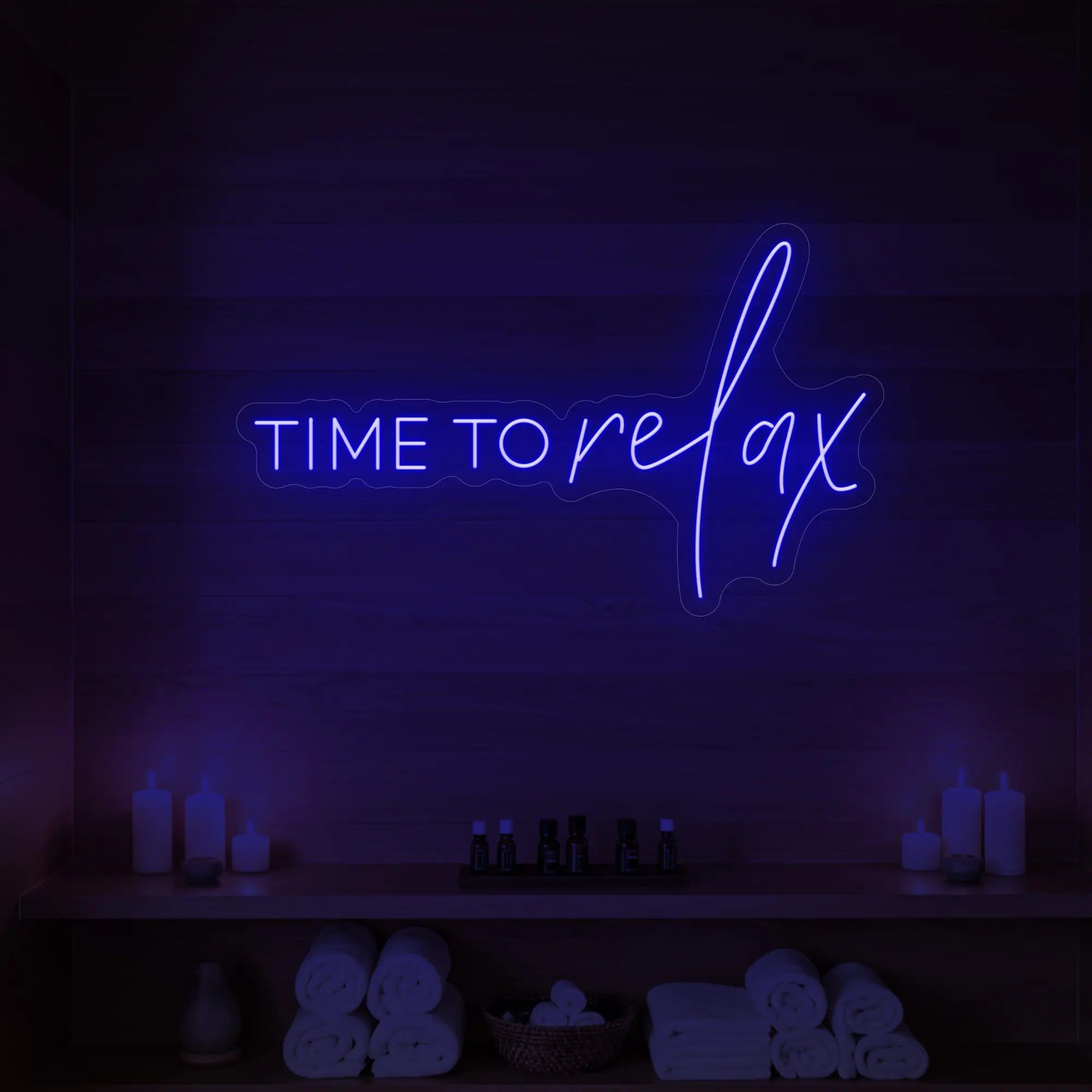 Photo of the 'TIME TO RELAX' neon sign glowing in deep blue against a styled interior wall.