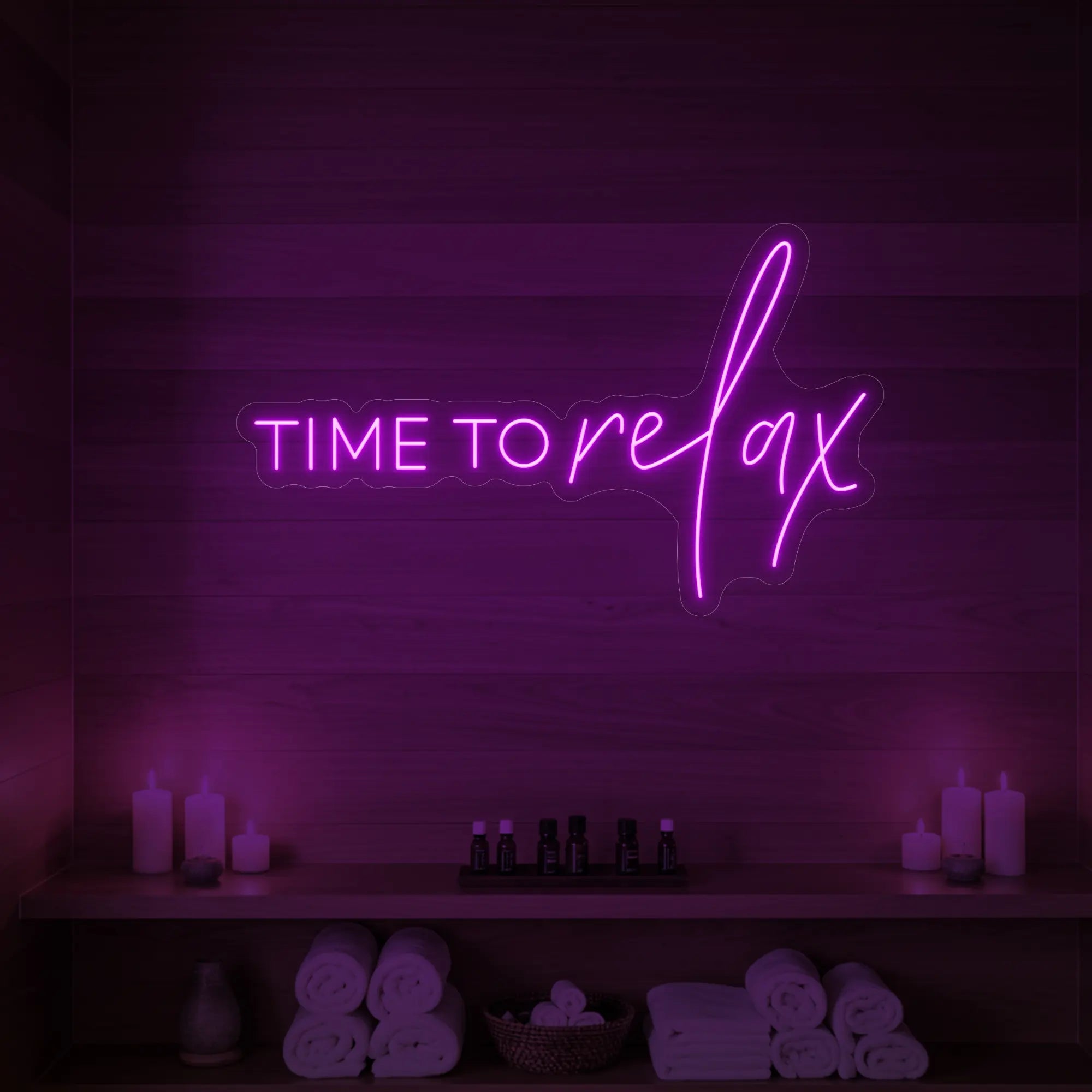 Photo of the 'TIME TO RELAX' neon sign glowing in deep pink against a styled interior wall.