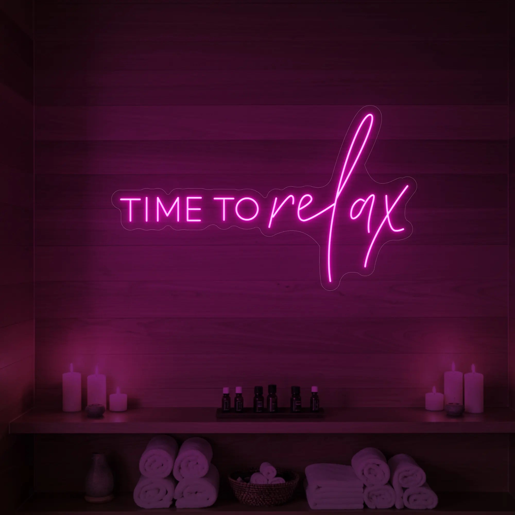 Photo of the 'TIME TO RELAX' neon sign glowing in light pink against a styled interior wall.