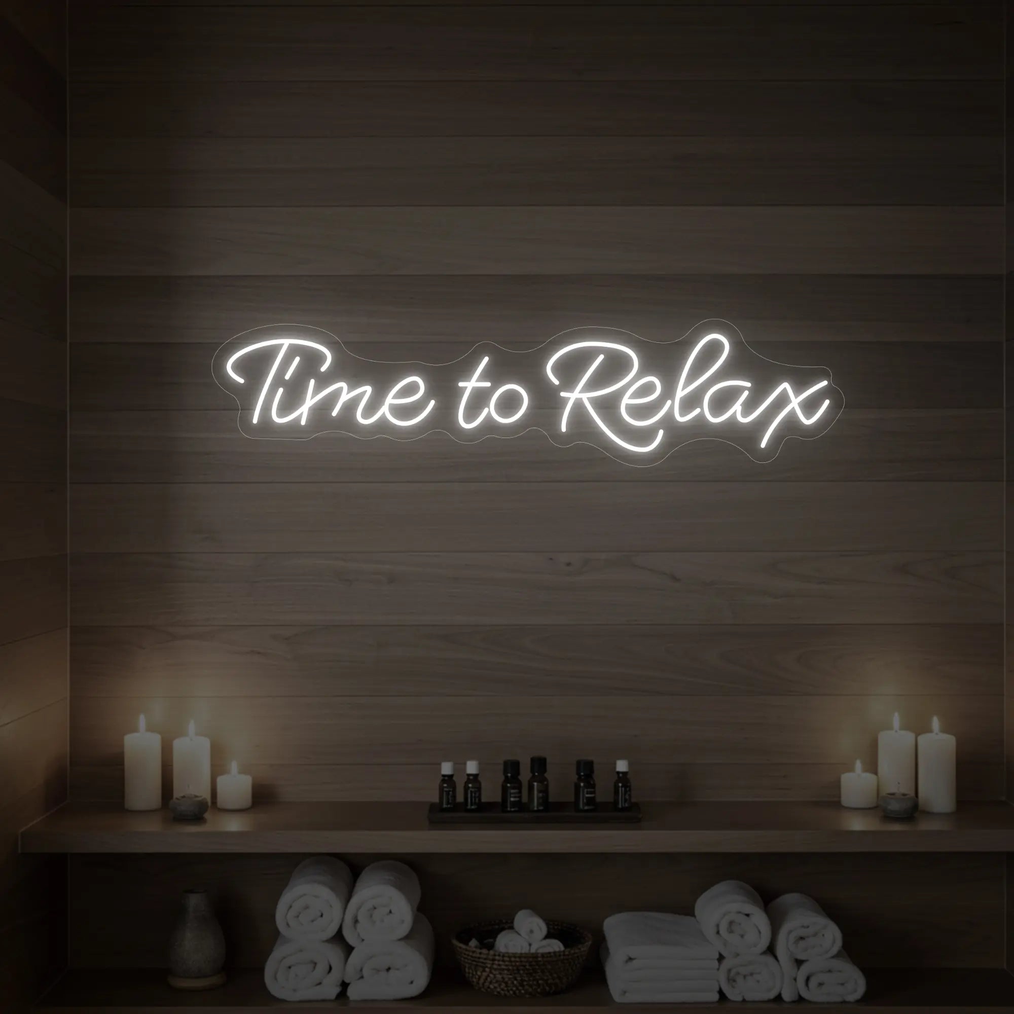 Photo of the 'Time to Relax' neon sign glowing in cool white against a styled interior wall.