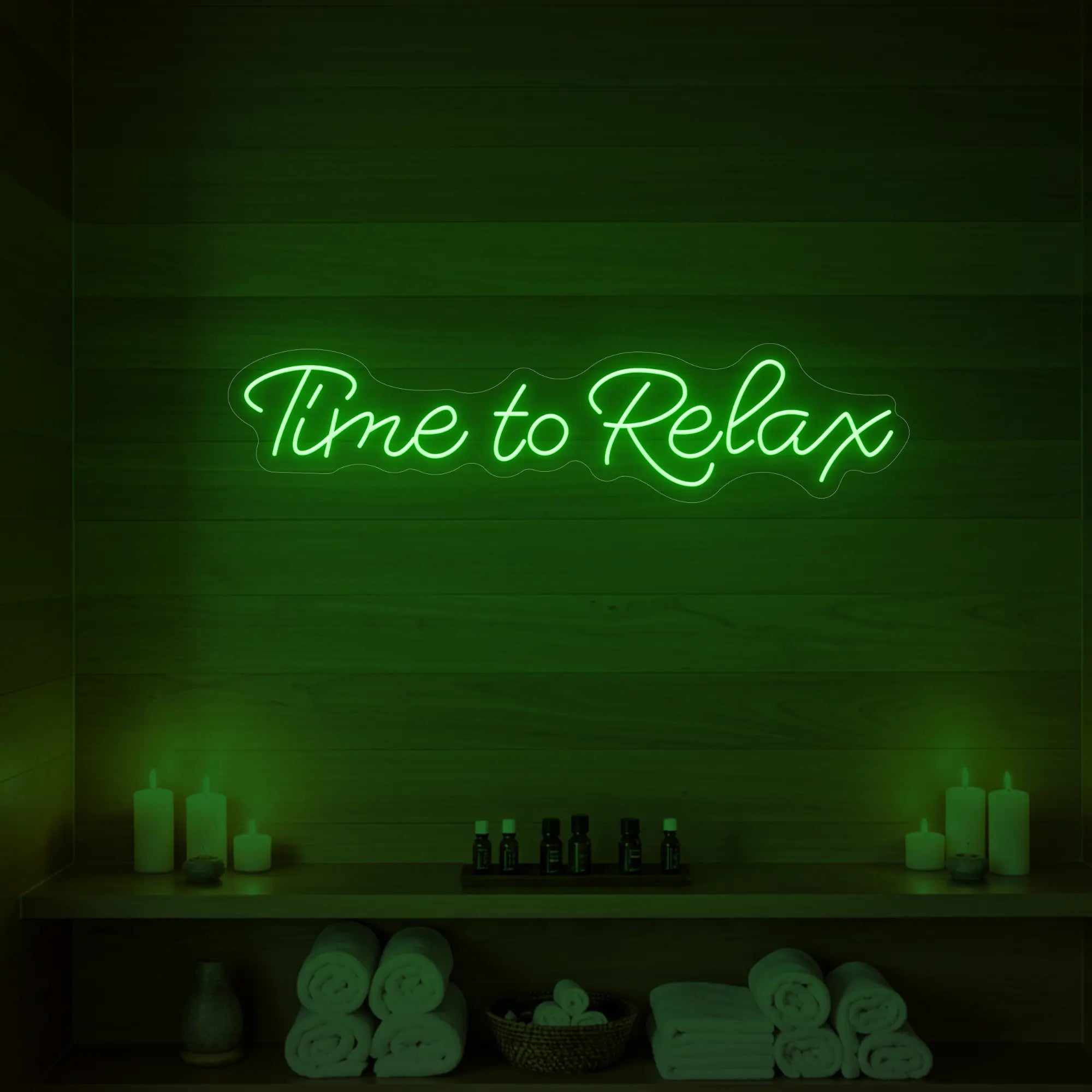 Photo of the 'Time to Relax' neon sign glowing in green against a styled interior wall.