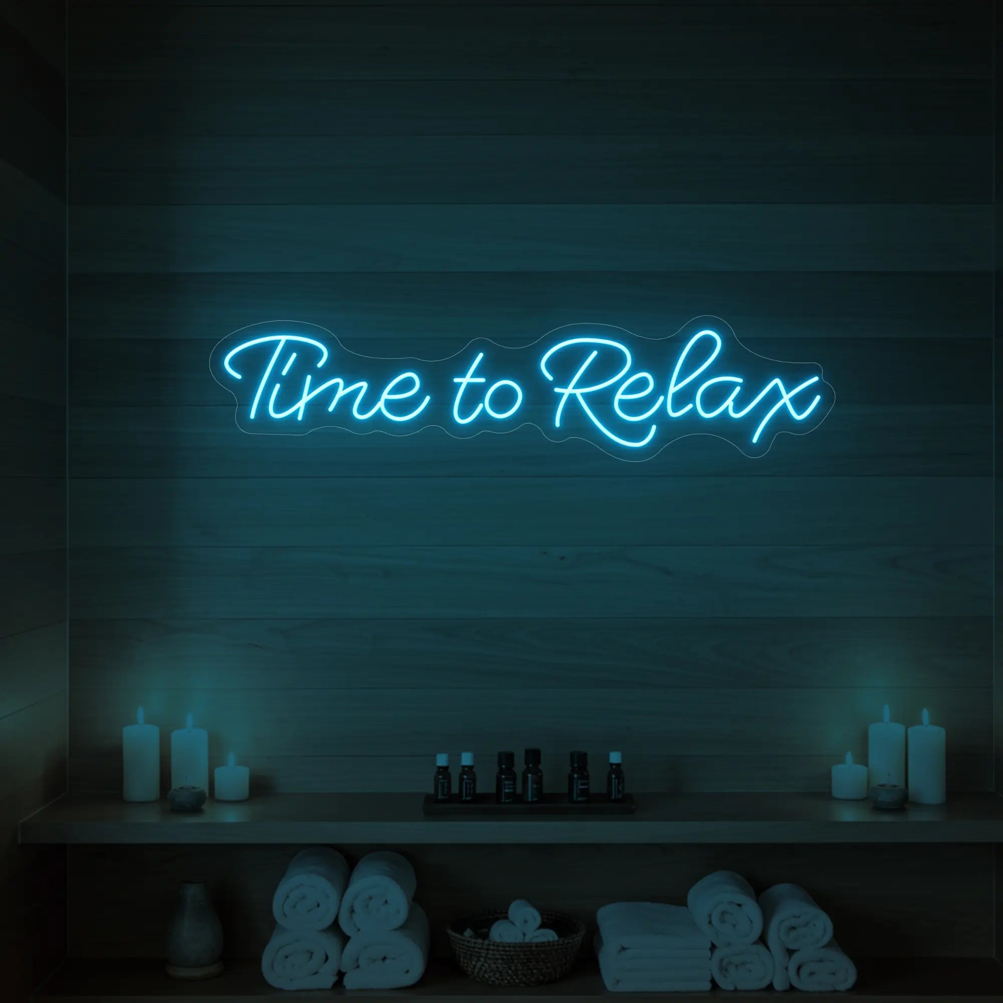 Photo of the 'Time to Relax' neon sign glowing in ice blue against a styled interior wall.
