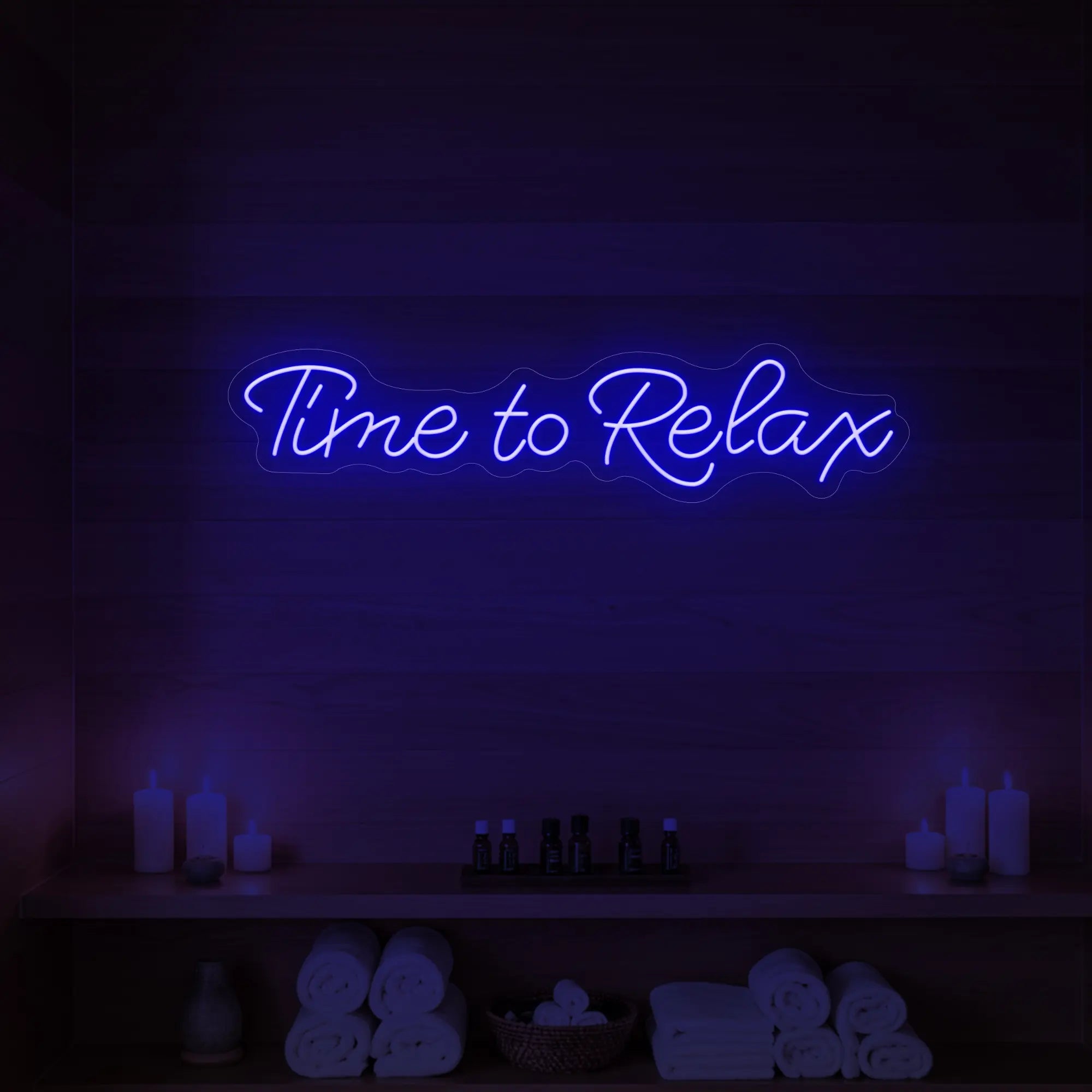 Photo of the 'Time to Relax' neon sign glowing in deep blue against a styled interior wall.