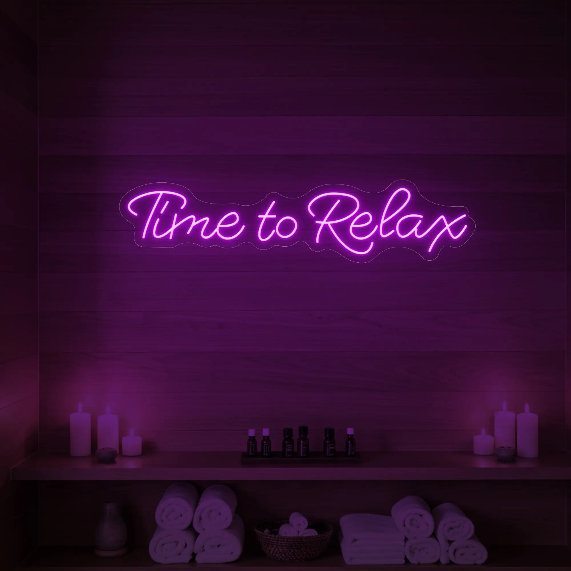 Photo of the 'Time to Relax' neon sign glowing in deep pink against a styled interior wall.