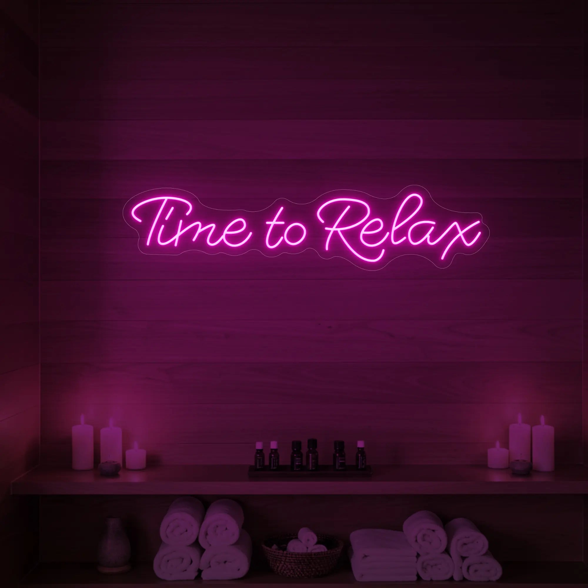 Photo of the 'Time to Relax' neon sign glowing in light pink against a styled interior wall.