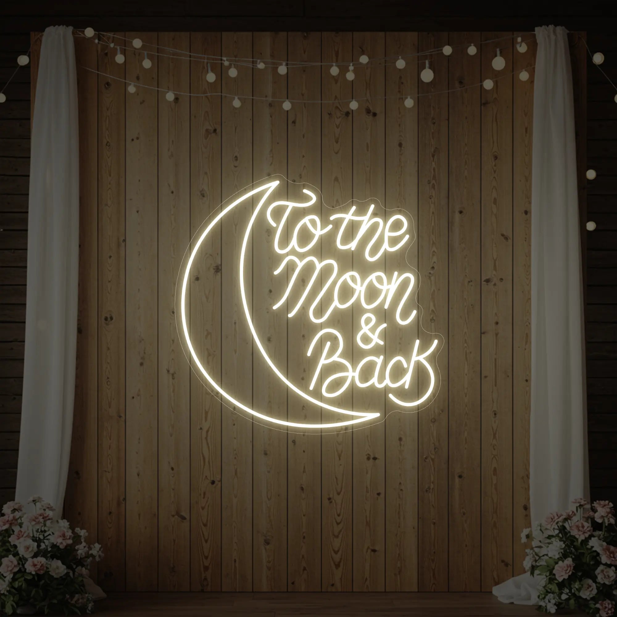 'To The Moon & Back' neon sign glowing in warm white against a styled interior wall.