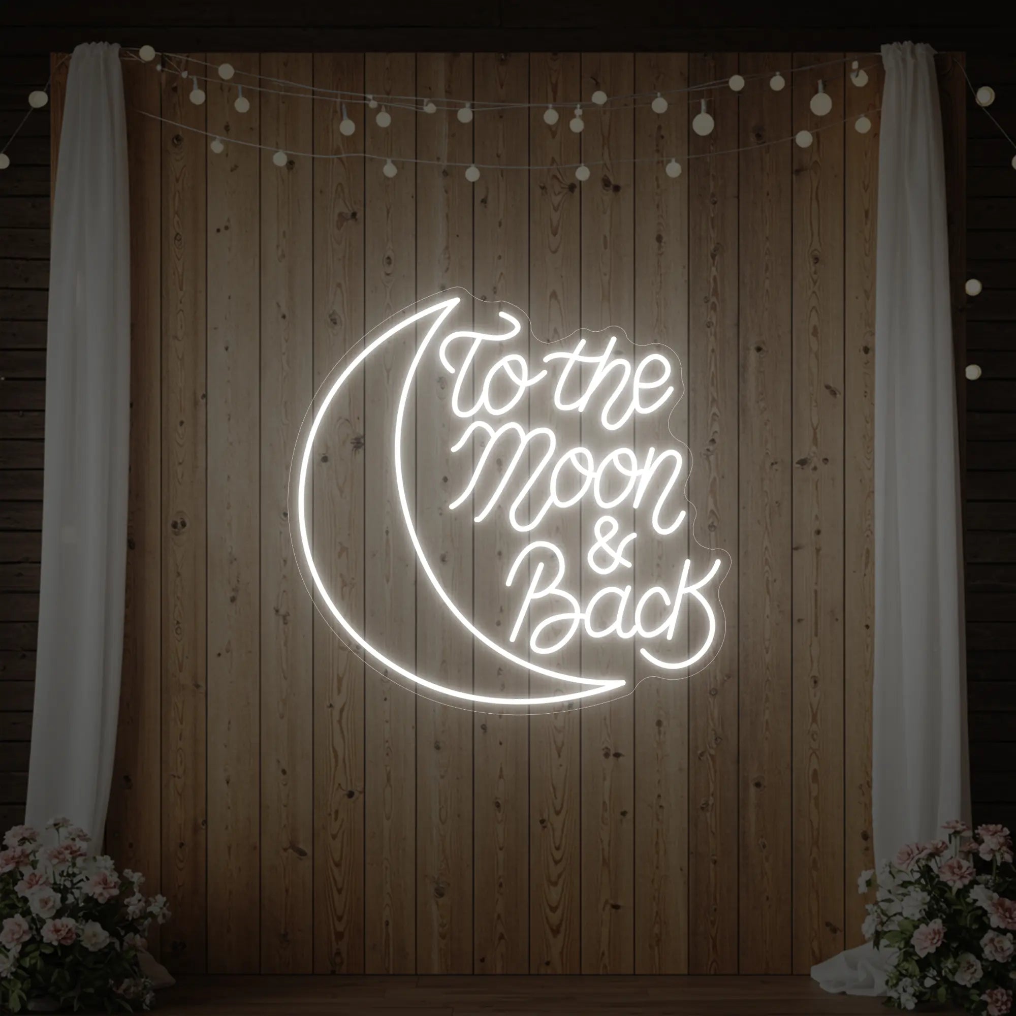 'To The Moon & Back' neon sign glowing in cool white against a styled interior wall.