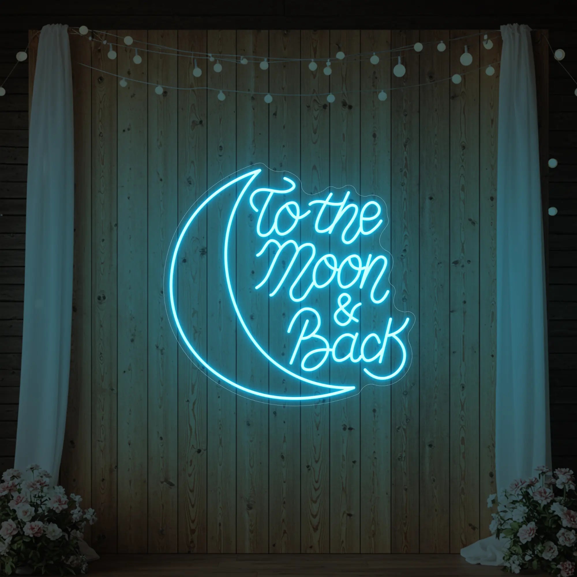 'To The Moon & Back' neon sign glowing in ice blue against a styled interior wall.