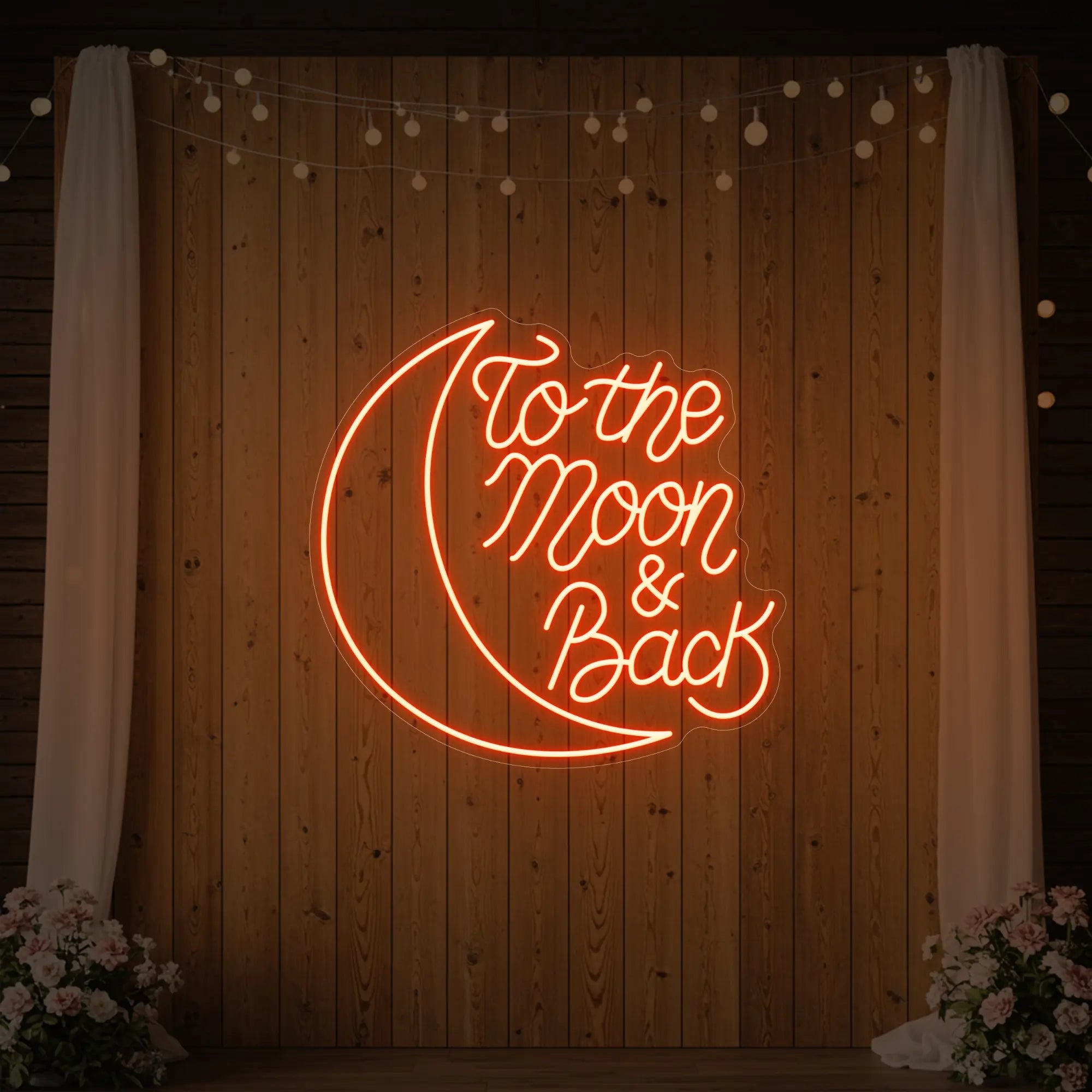 'To The Moon & Back' neon sign glowing in golden yellow against a styled interior wall.