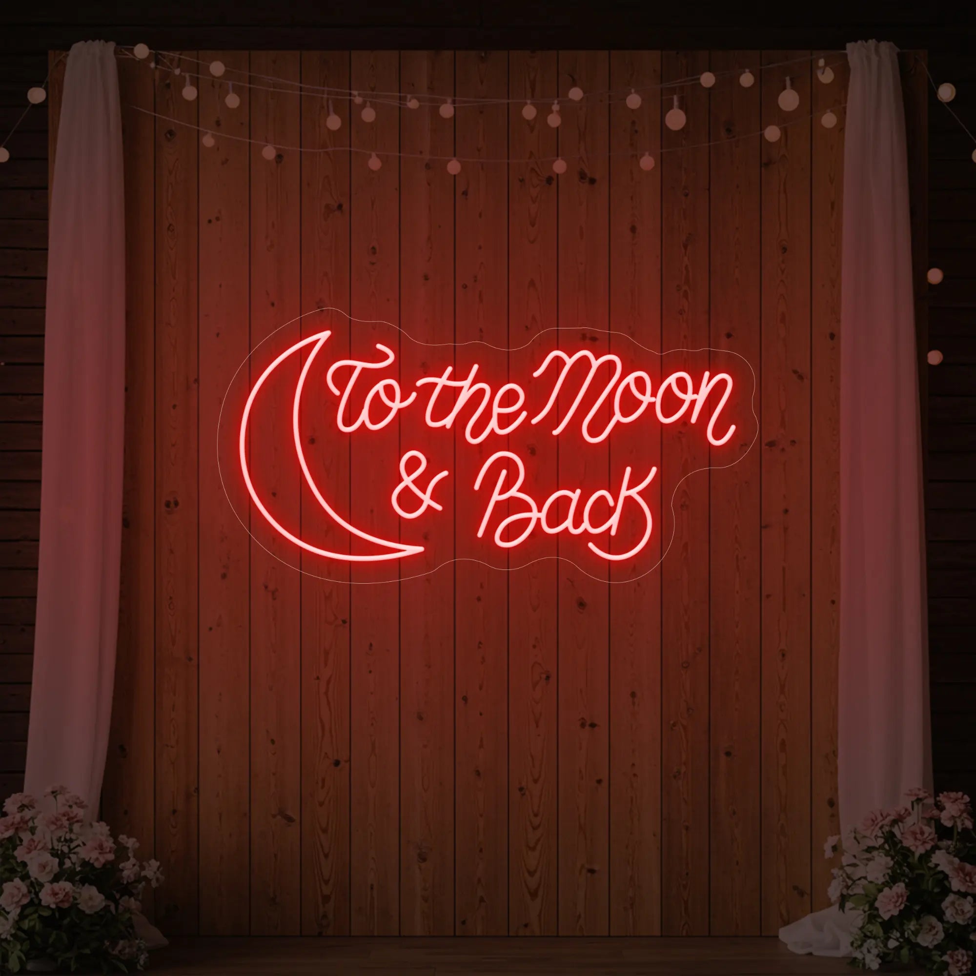 'To The Moon And Back' neon sign glowing in red against a styled interior wall.