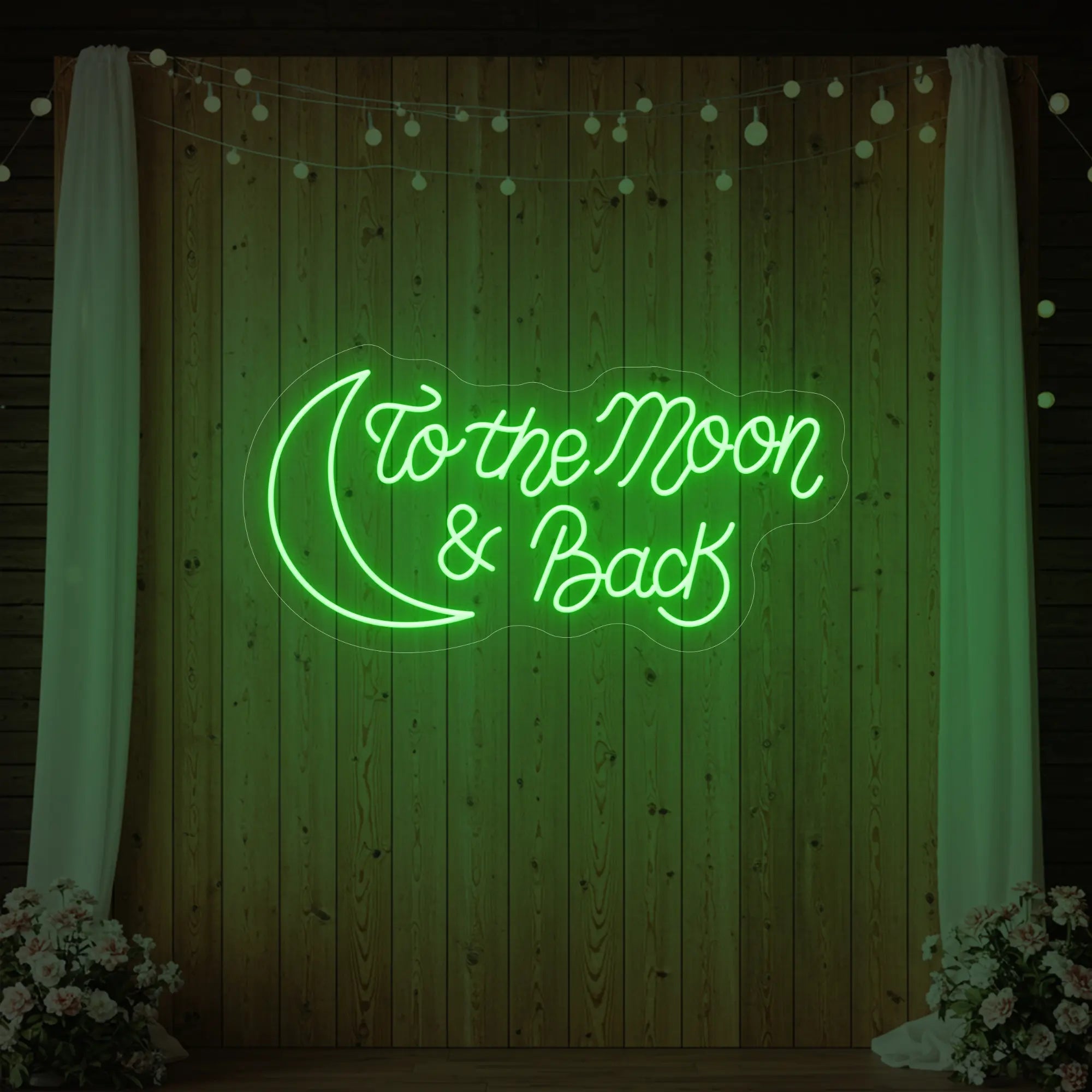 'To The Moon And Back' neon sign glowing in green against a styled interior wall.
