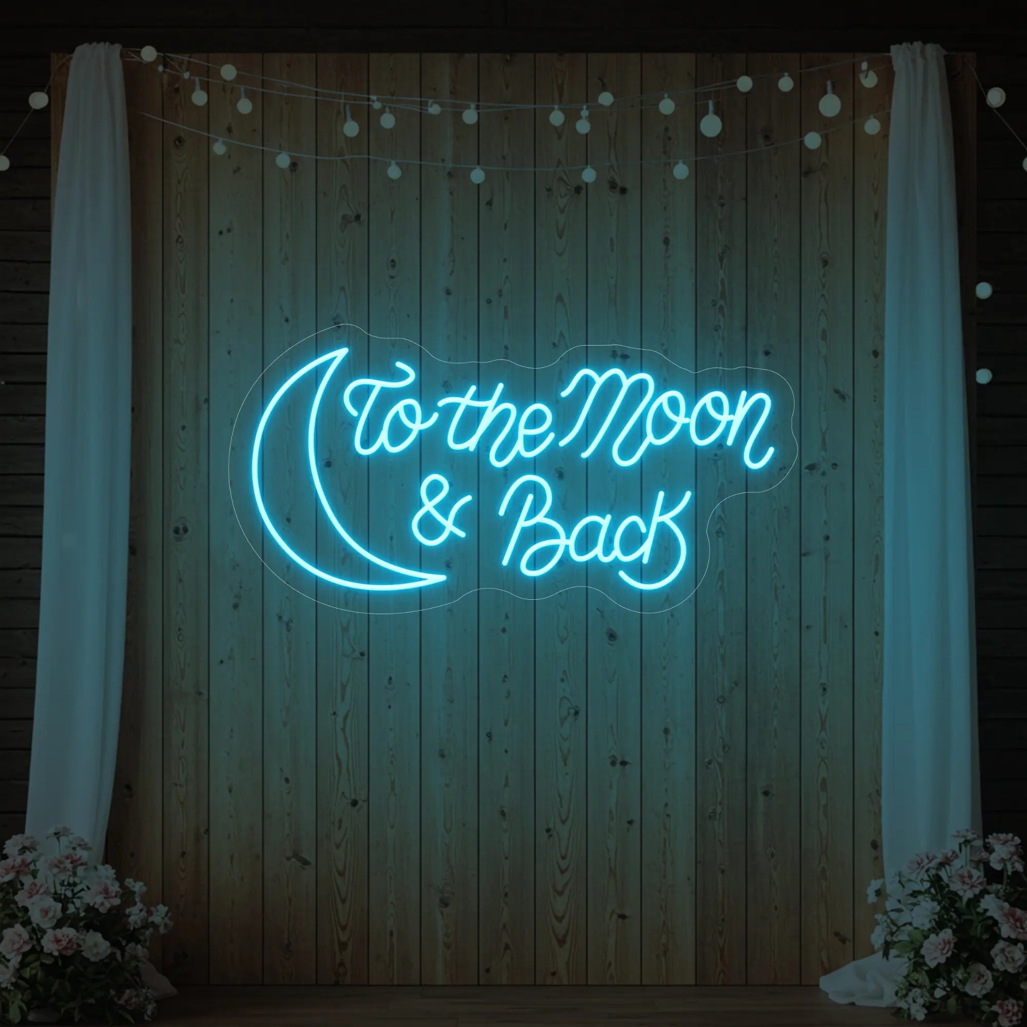 'To The Moon And Back' neon sign glowing in ice blue against a styled interior wall.