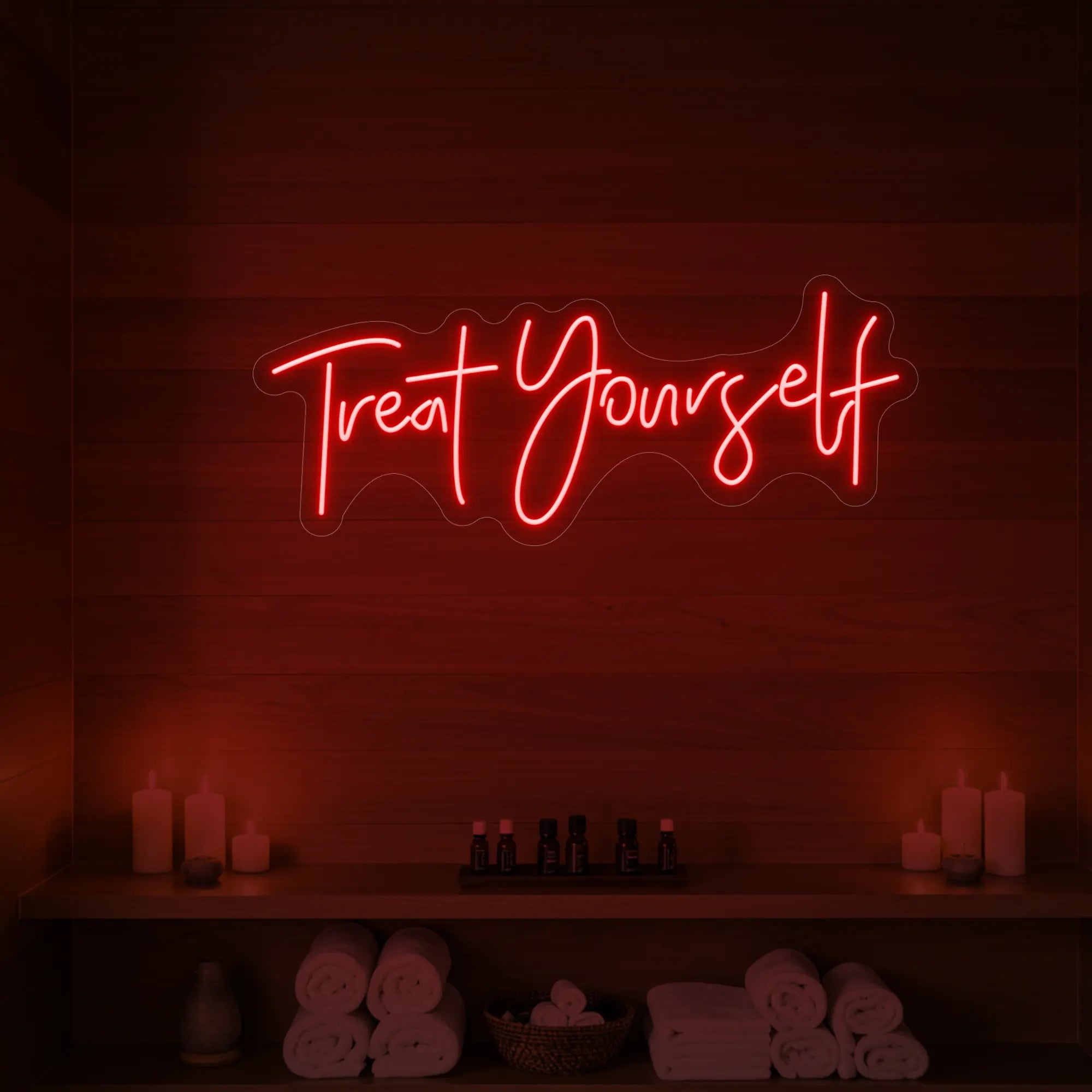 Photo of the 'Treat Yourself' neon sign glowing in red against a styled interior wall.