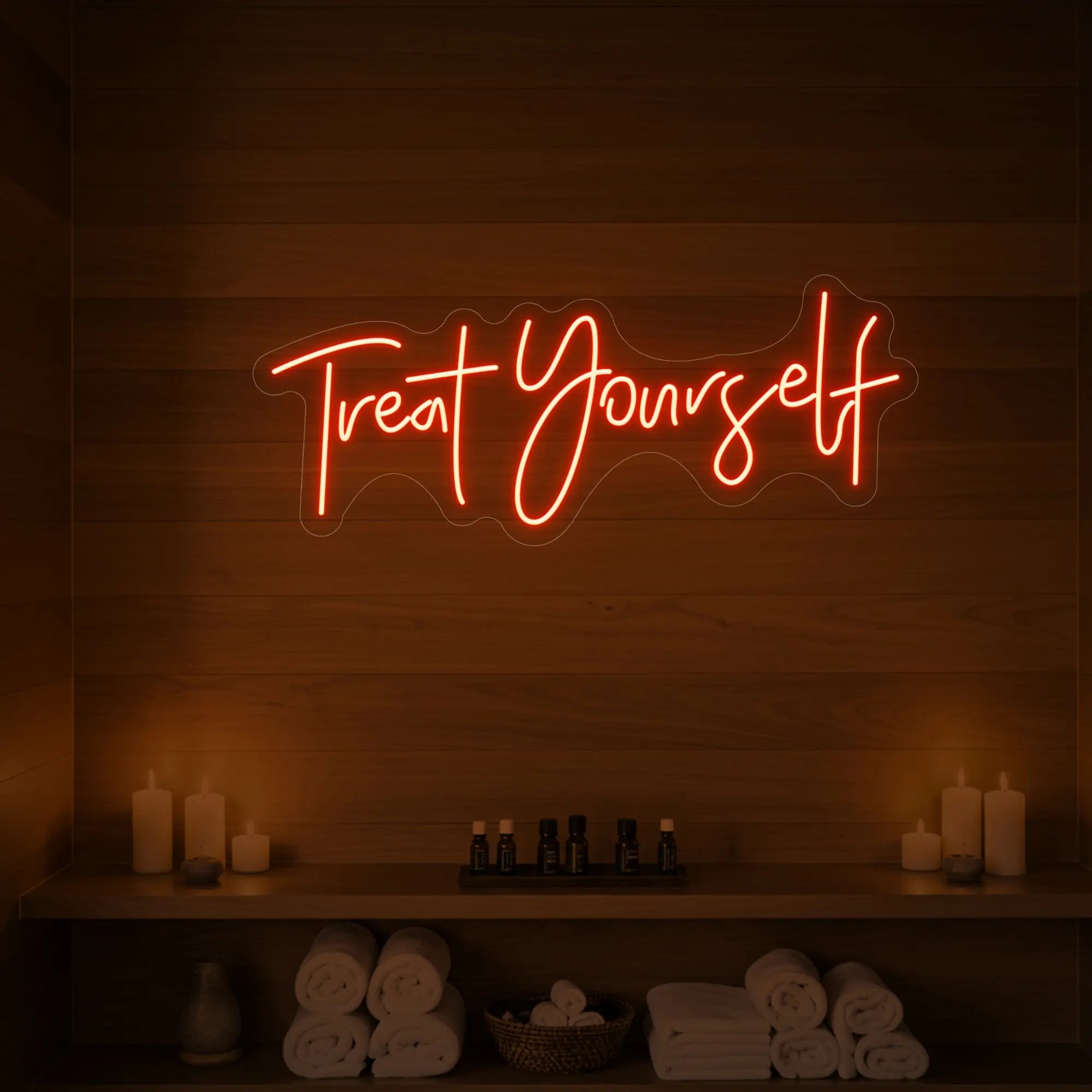 Photo of the 'Treat Yourself' neon sign glowing in golden yellow against a styled interior wall.