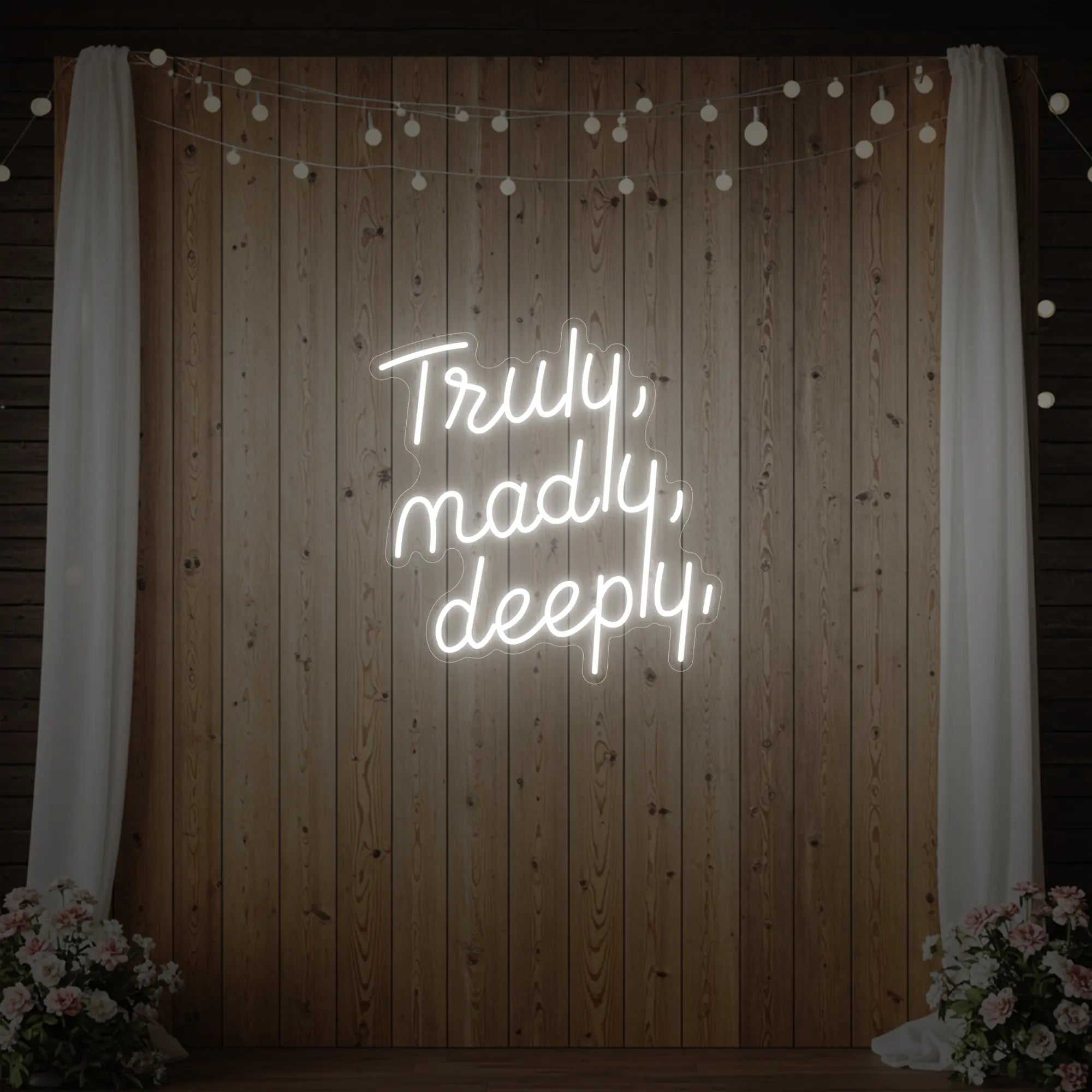 'Truly, Madly, Deeply' neon sign glowing in cool white against a styled interior wall.