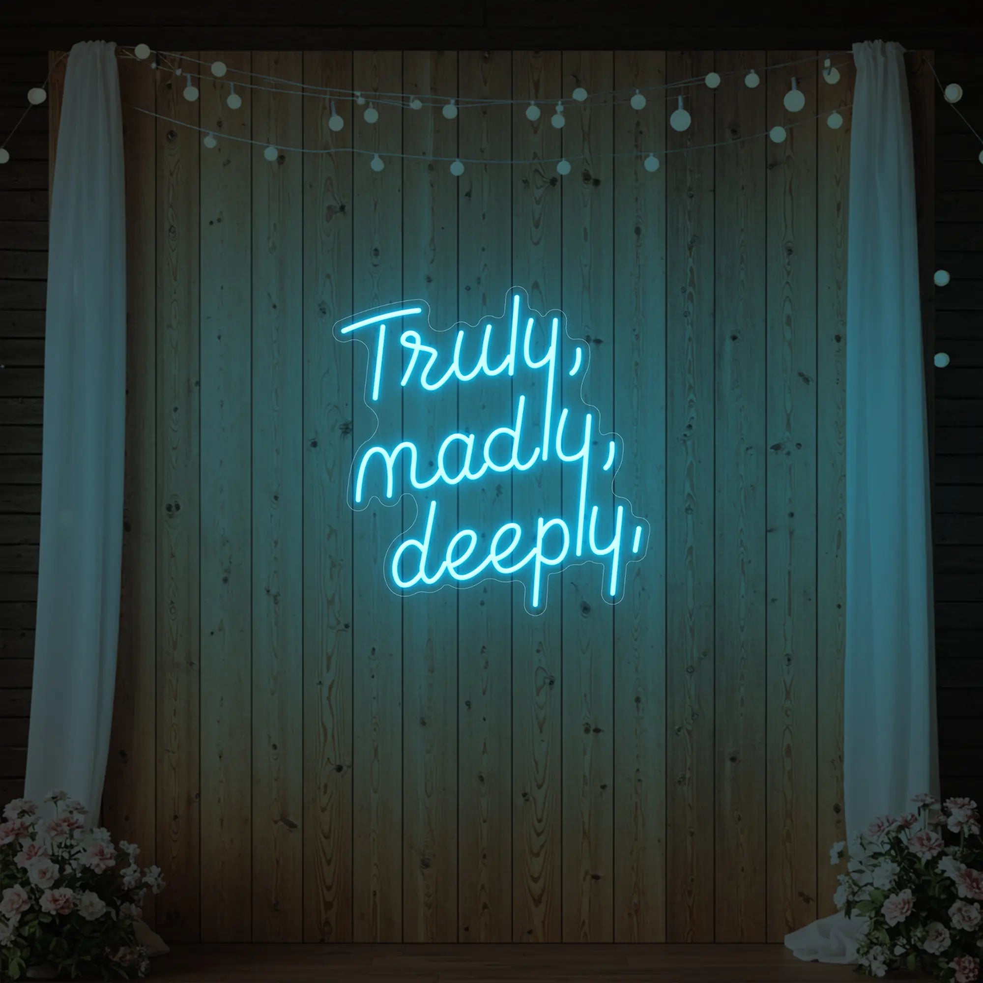 'Truly, Madly, Deeply' neon sign glowing in ice blue against a styled interior wall.