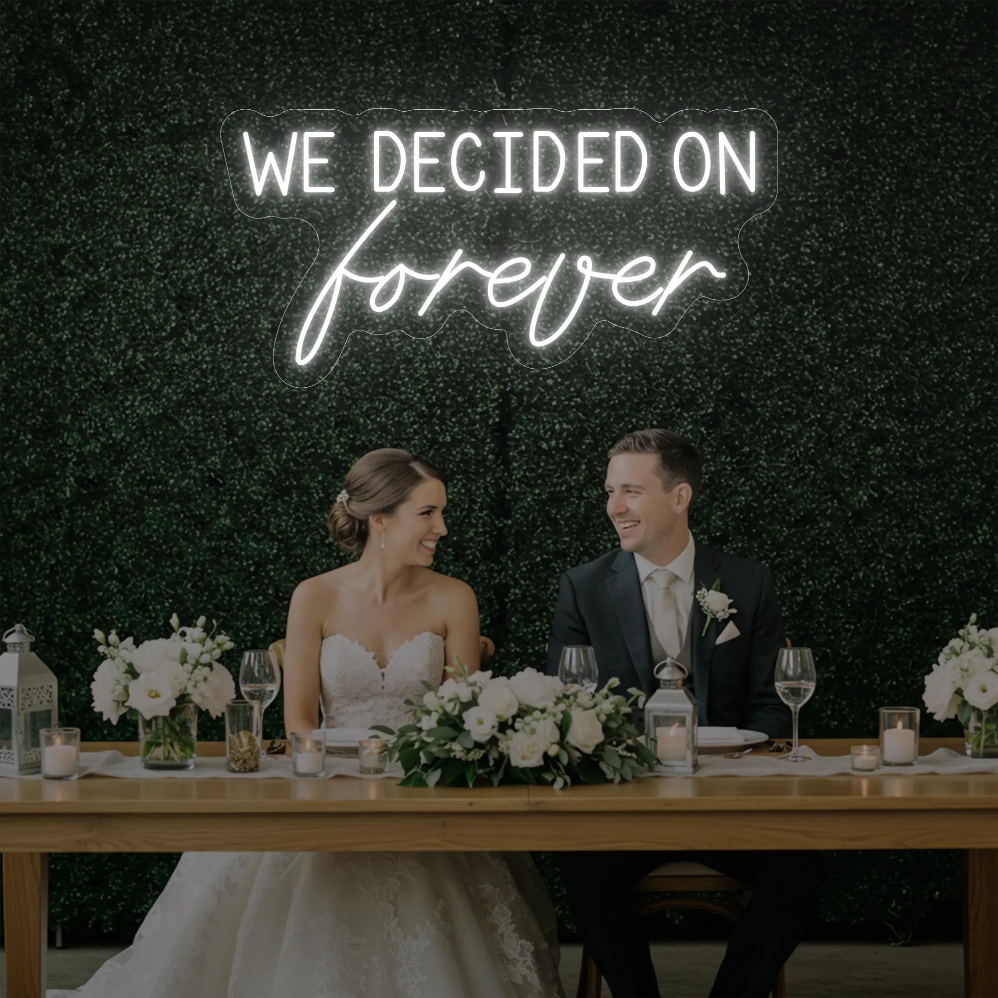 'We Decided On Forever' neon sign glowing in cool white against a styled interior wall.