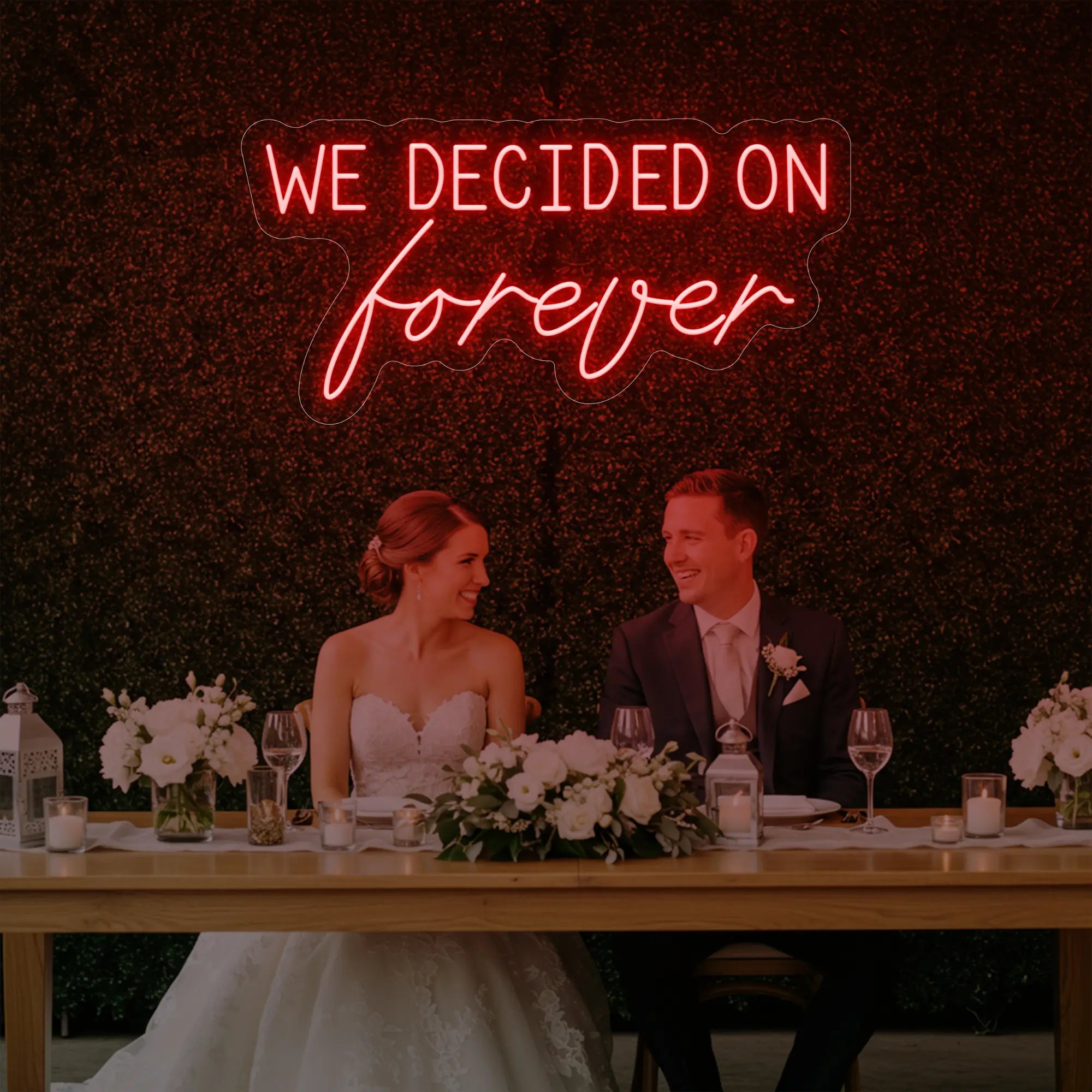 'We Decided On Forever' neon sign glowing in red against a styled interior wall.