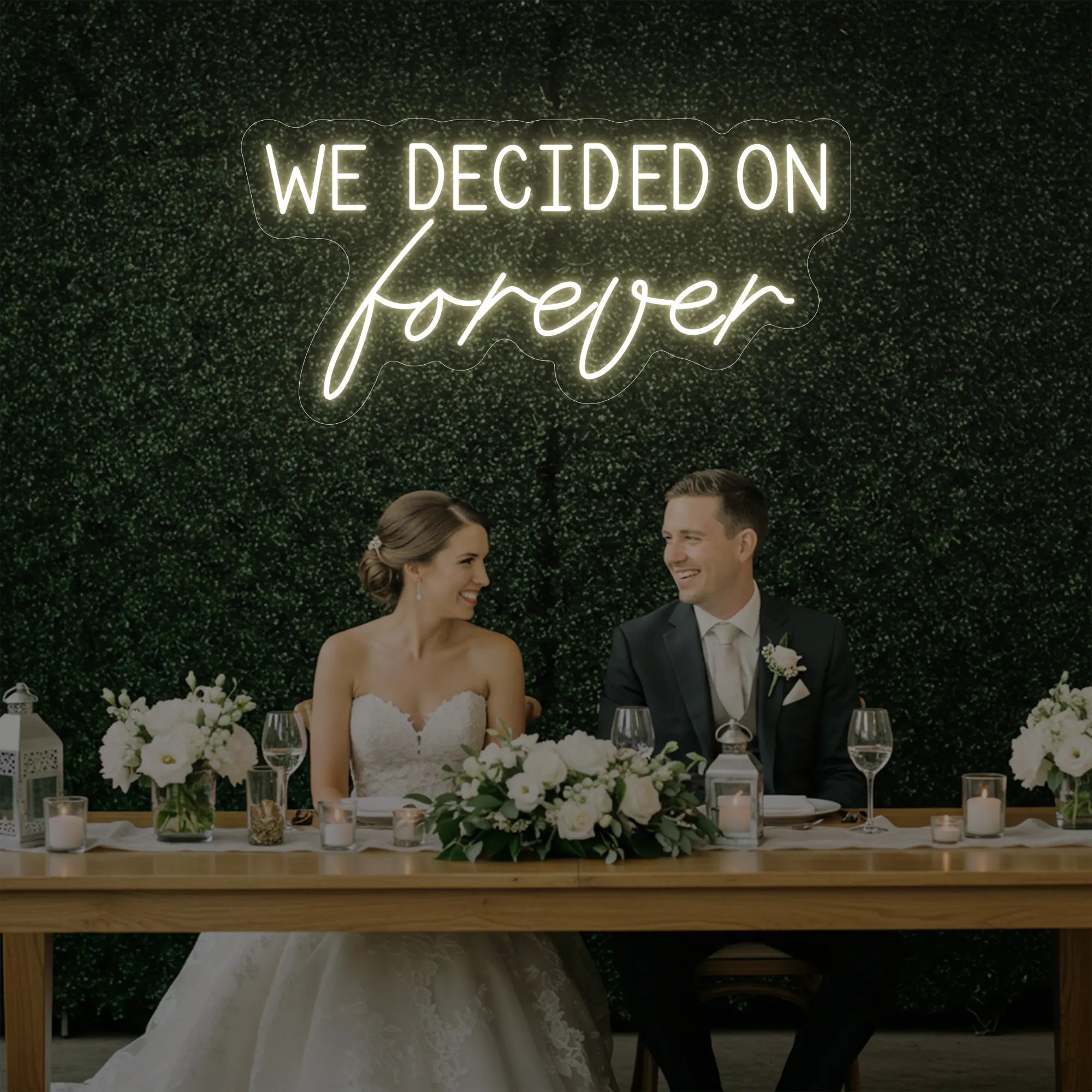 'We Decided On Forever' neon sign glowing in warm white against a styled interior wall.