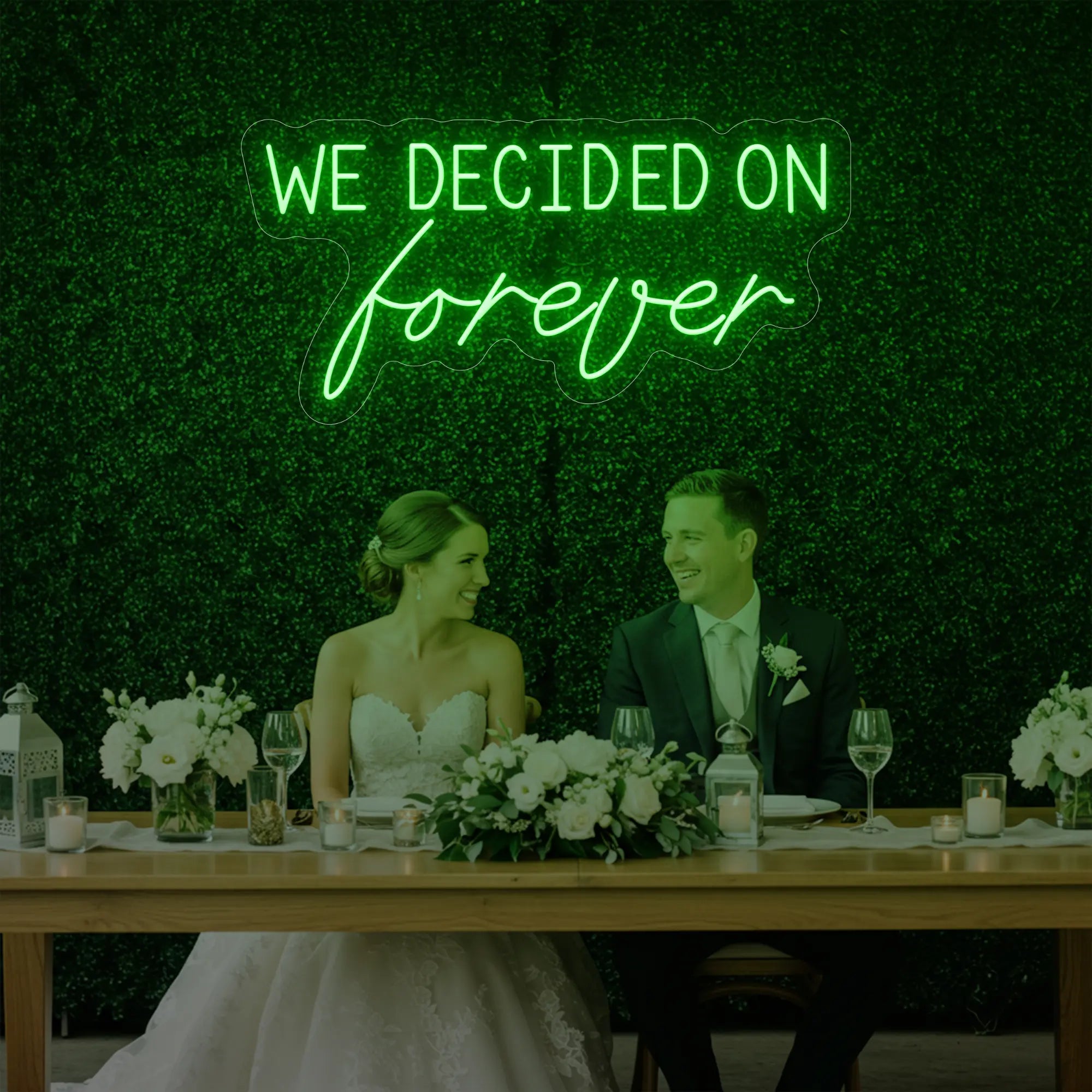'We Decided On Forever' neon sign glowing in green against a styled interior wall.