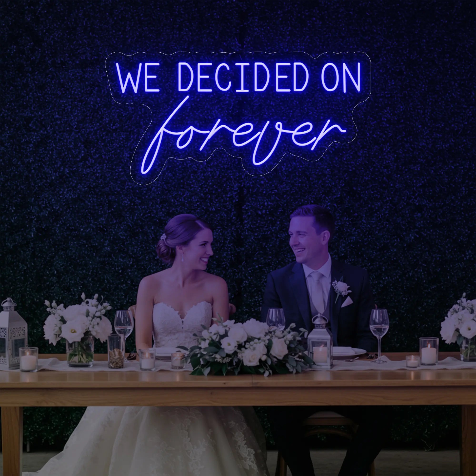 'We Decided On Forever' neon sign glowing in deep blue against a styled interior wall.