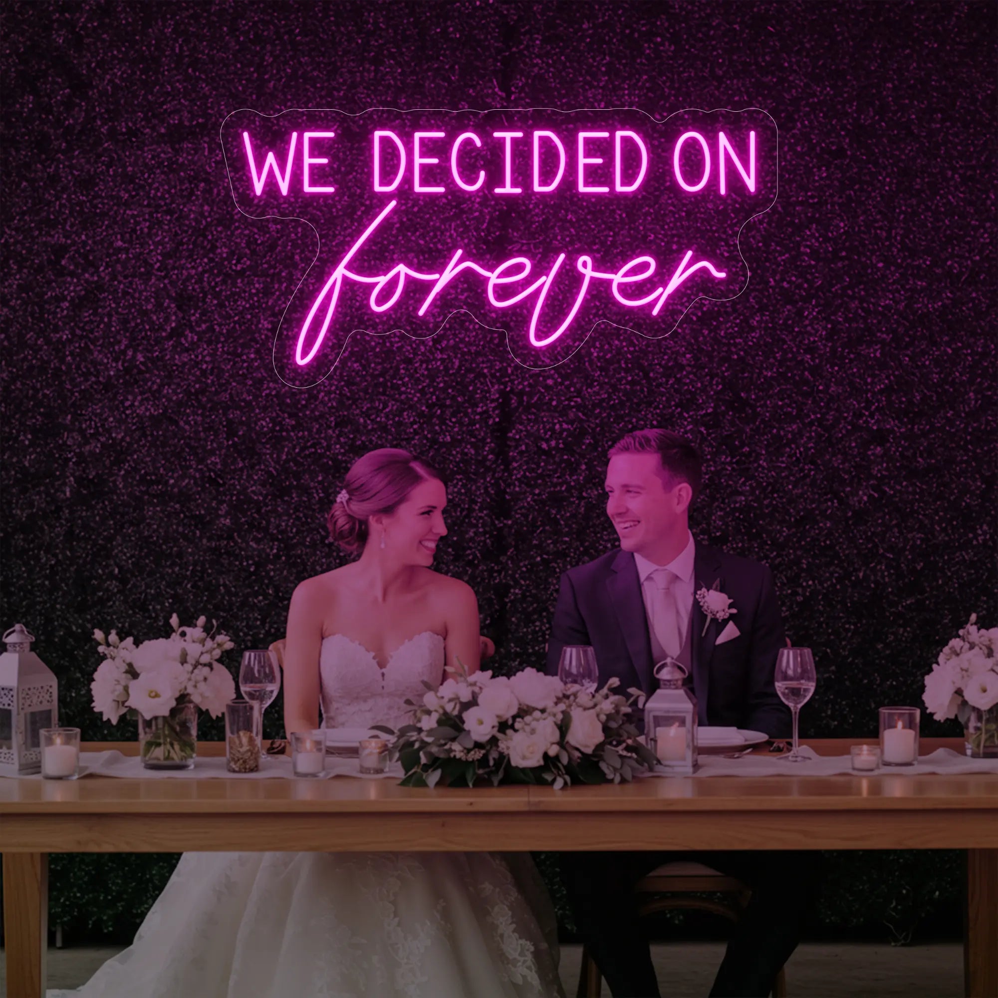 'We Decided On Forever' neon sign glowing in light pink against a styled interior wall.