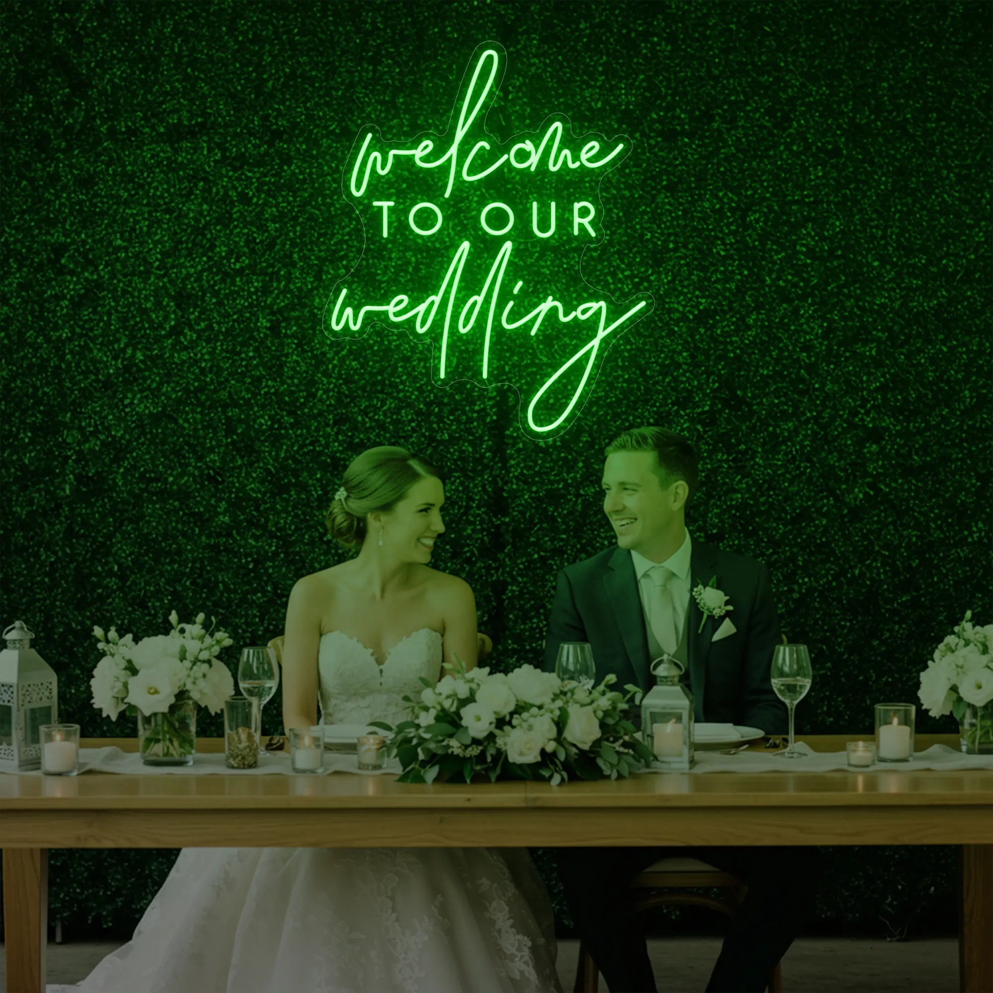 'Welcome To Our Wedding' neon sign glowing in green against a styled interior wall.