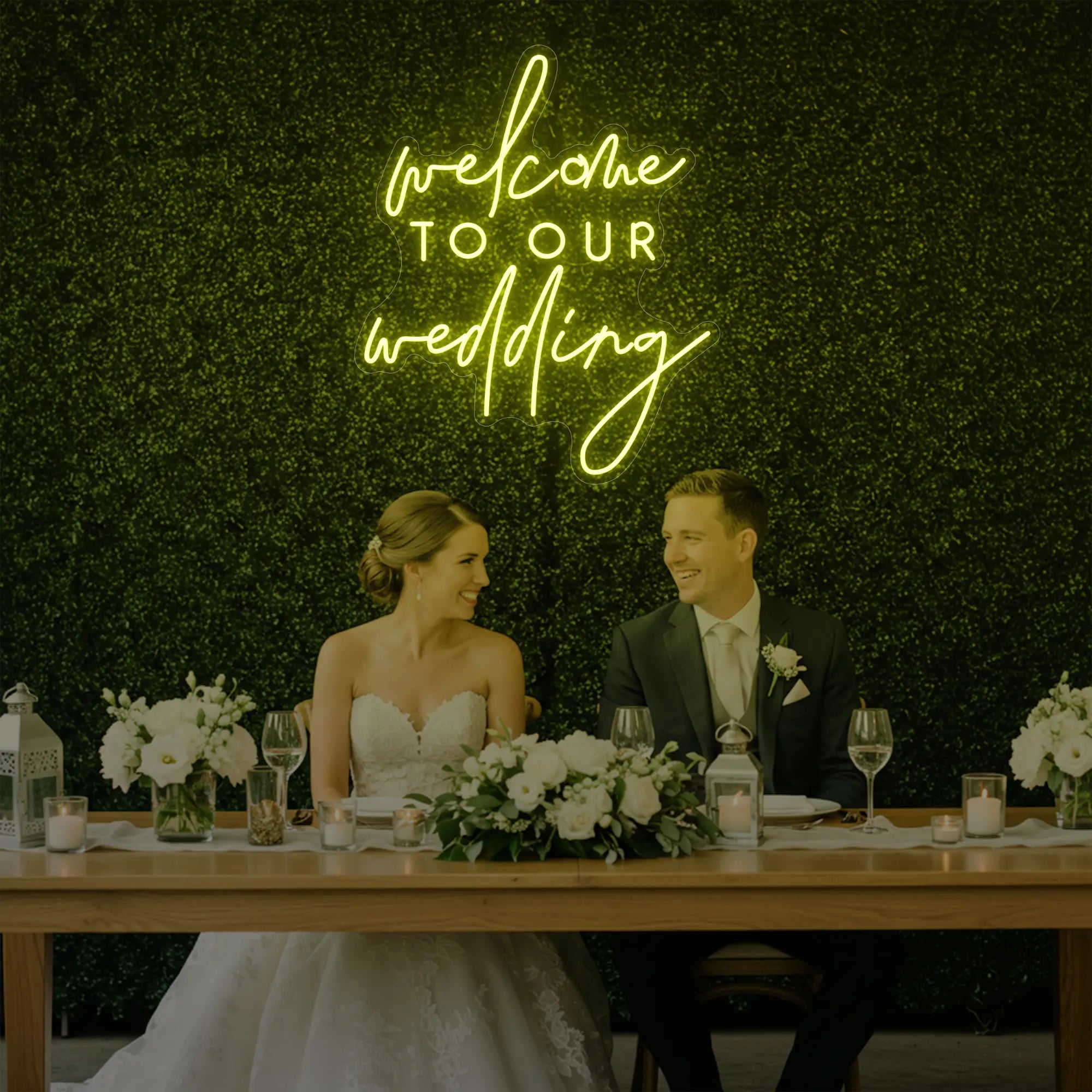 'Welcome To Our Wedding' neon sign glowing in lemon yellow against a styled interior wall.