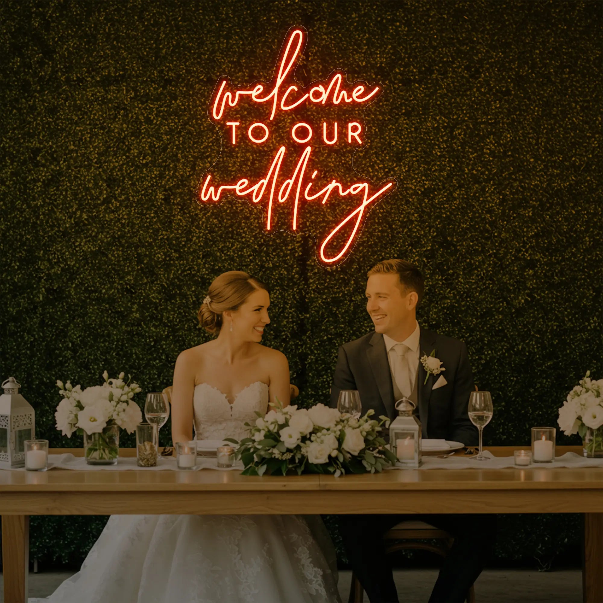 'Welcome To Our Wedding' neon sign glowing in golden yellow against a styled interior wall.