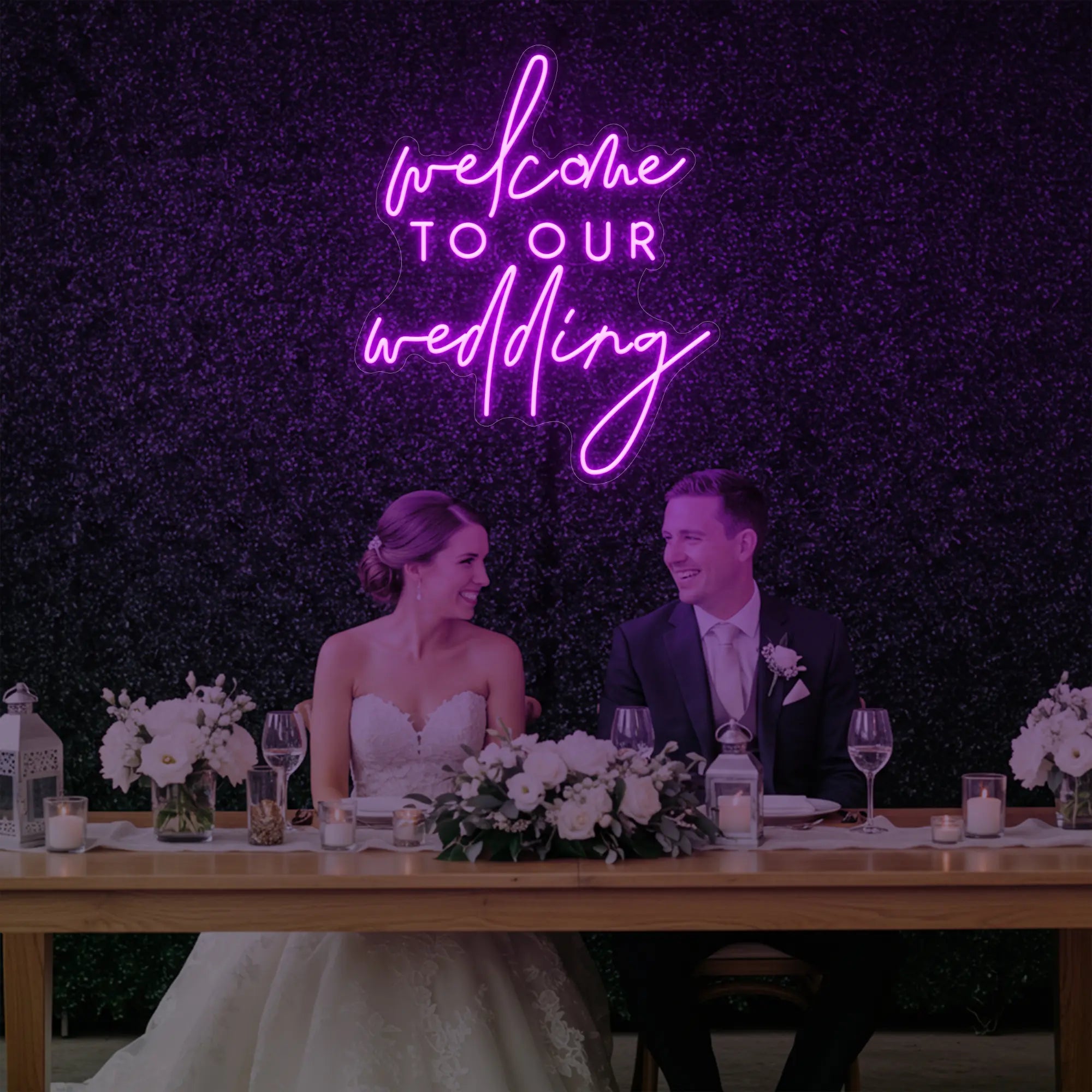 'Welcome To Our Wedding' neon sign glowing in deep pink against a styled interior wall.