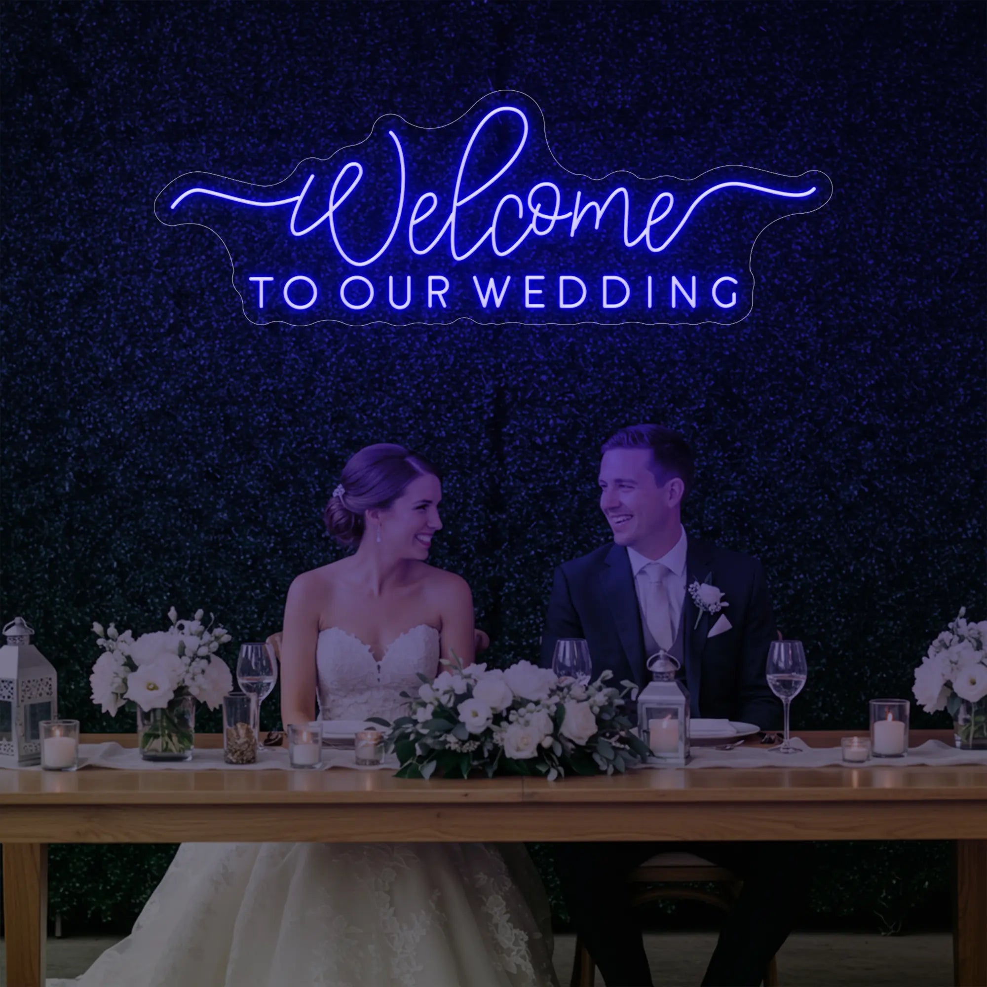'Welcome To Our Wedding' neon sign glowing in deep blue against a styled interior wall.
