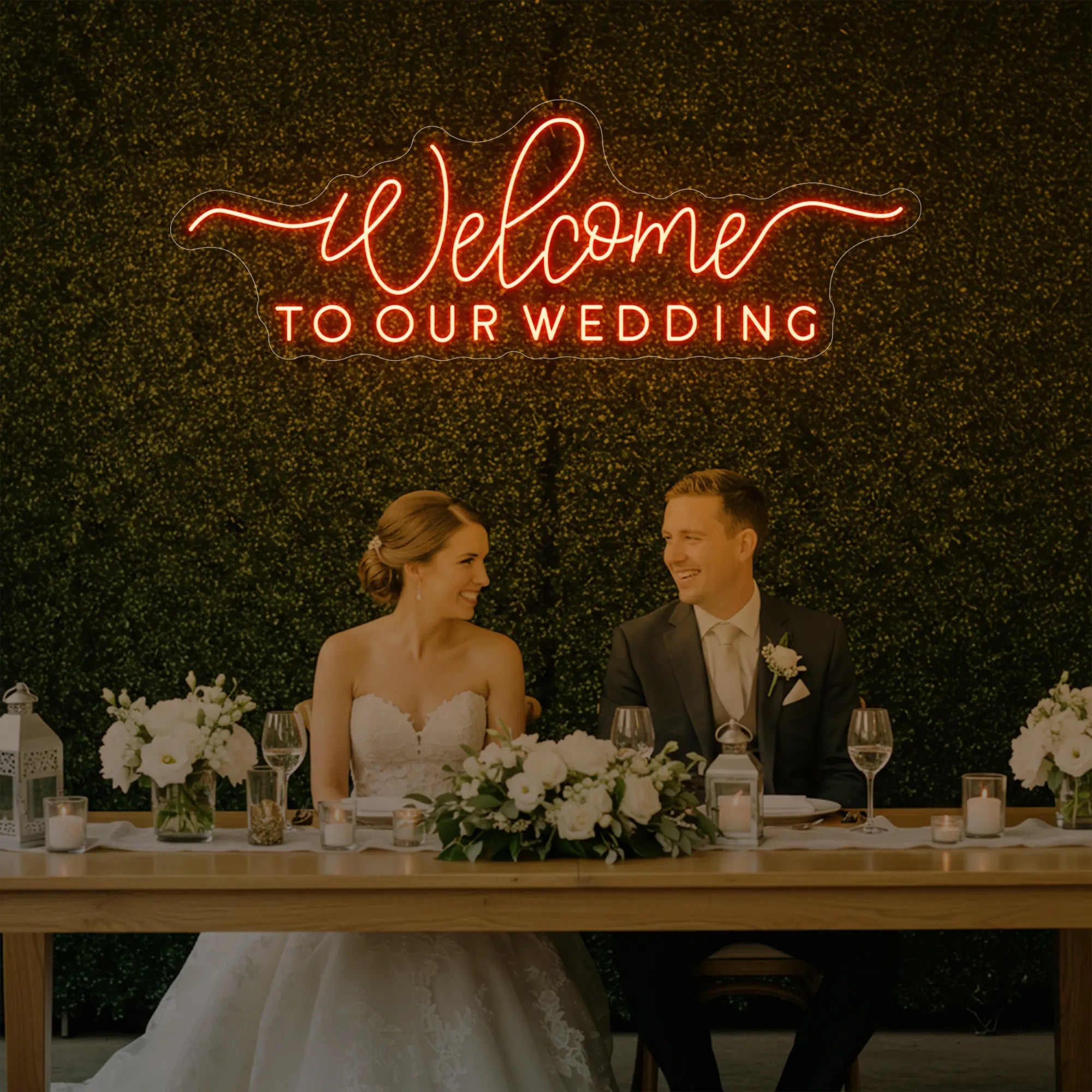 'Welcome To Our Wedding' neon sign glowing in golden yellow against a styled interior wall.