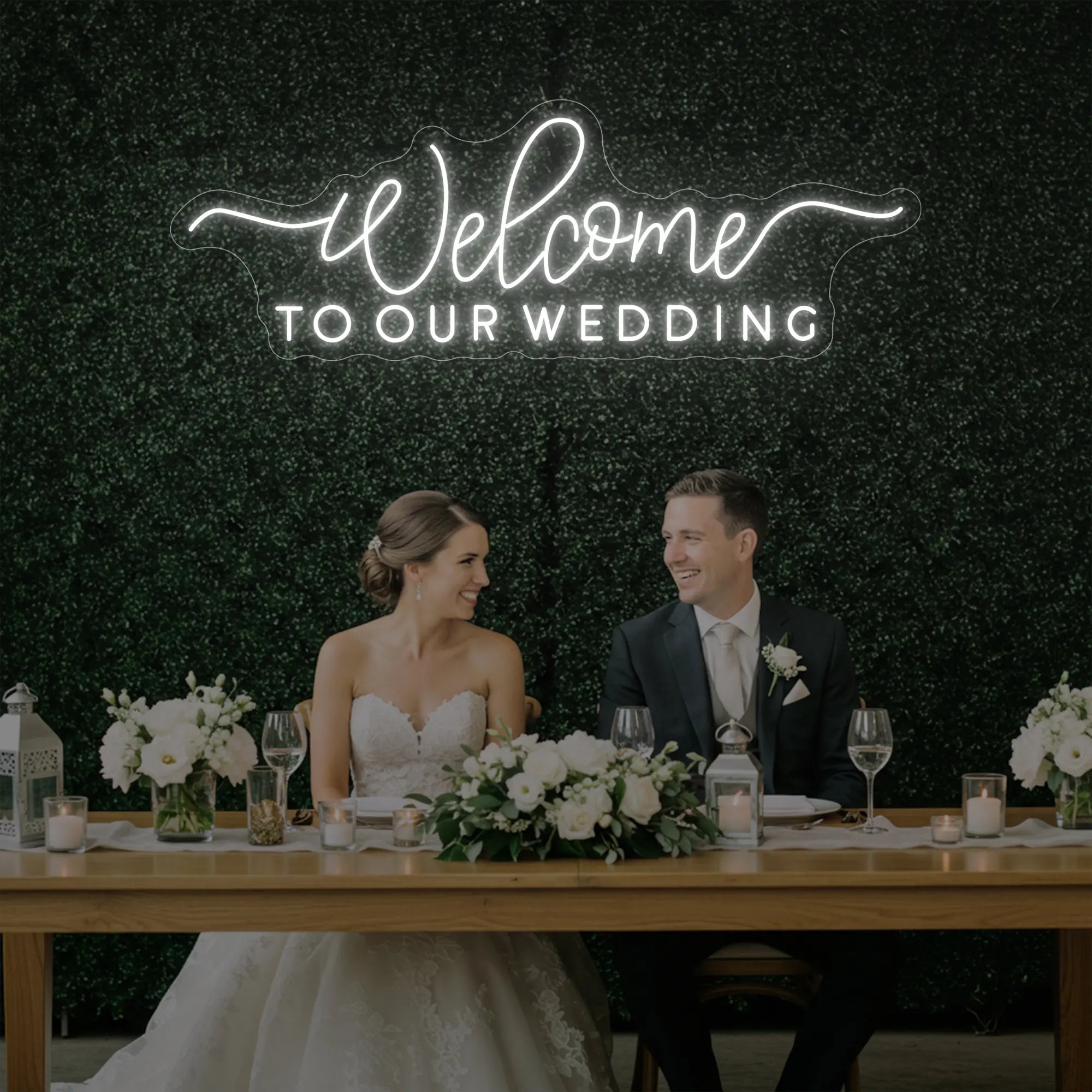 'Welcome To Our Wedding' neon sign glowing in cool white against a styled interior wall.