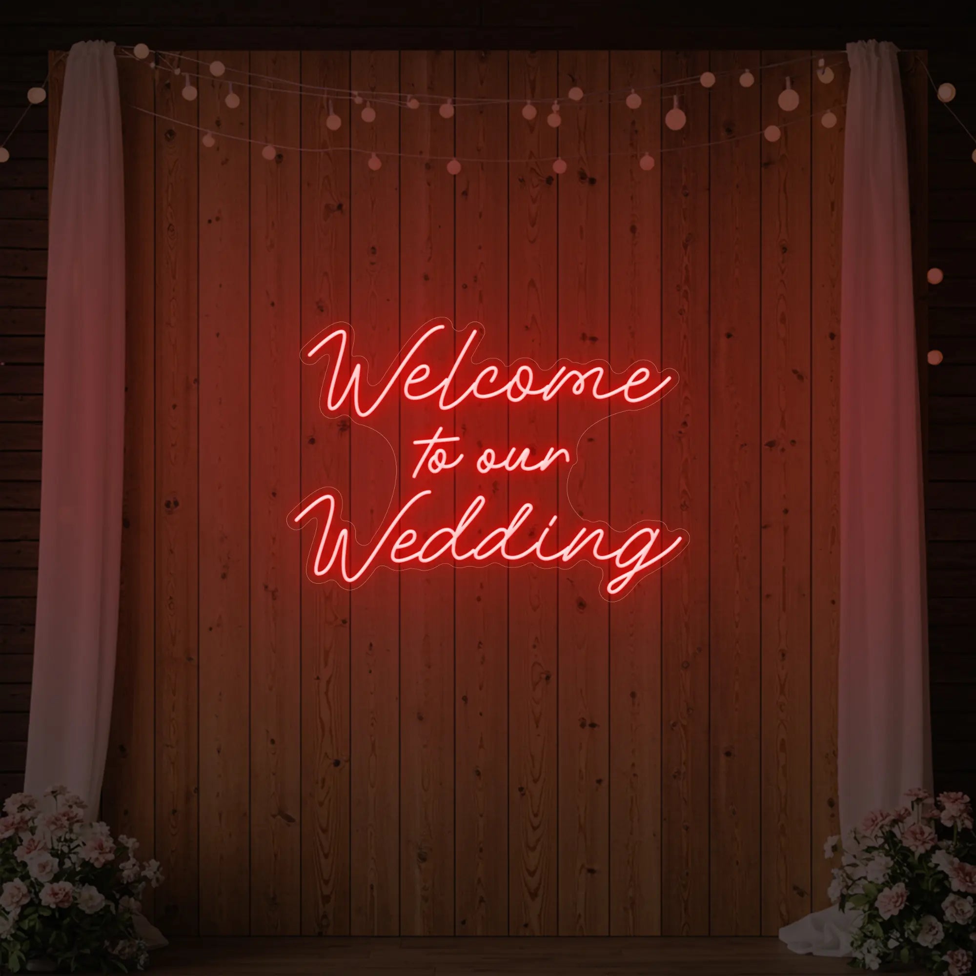 'Welcome To Our Wedding' neon sign glowing in red against a styled interior wall.