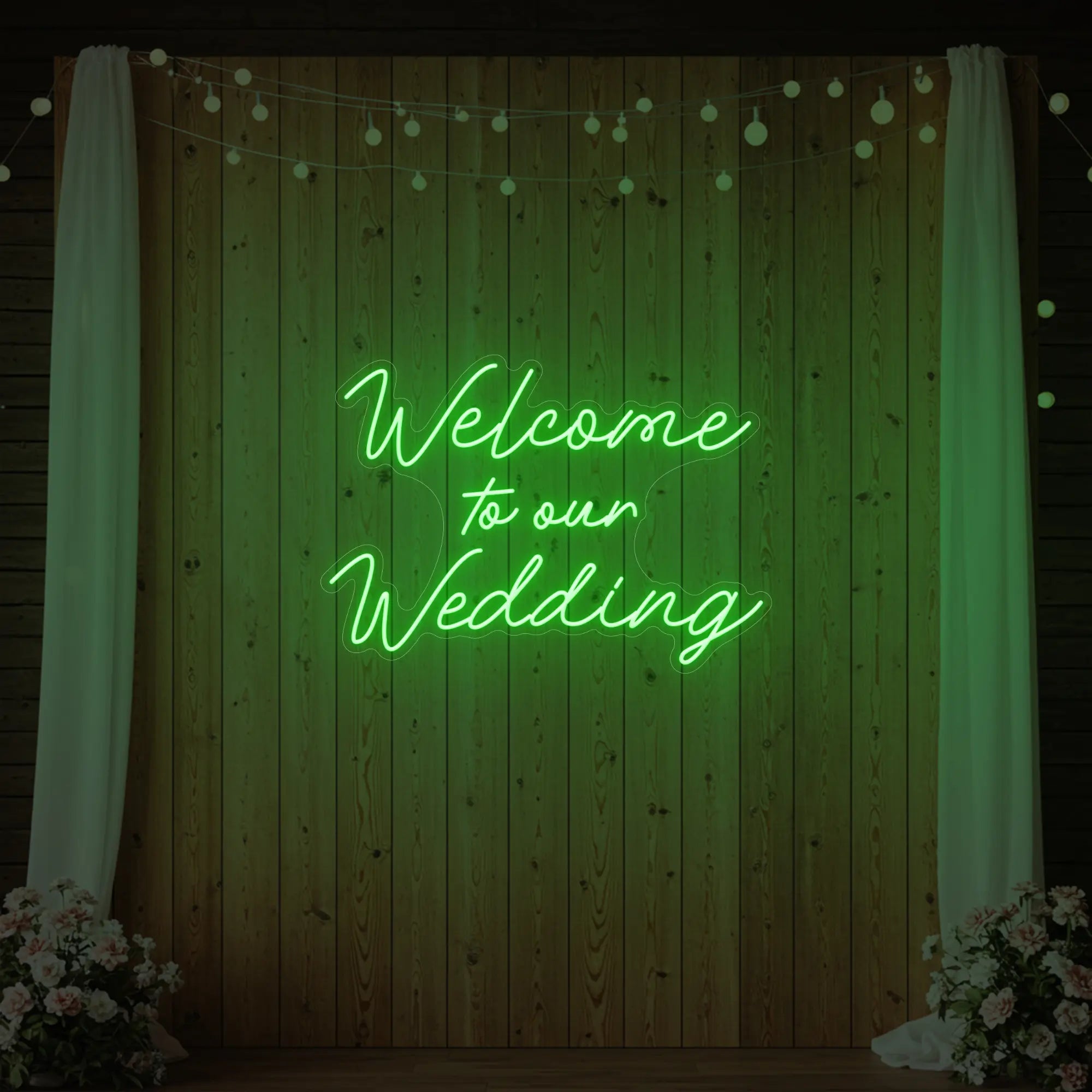 'Welcome To Our Wedding' neon sign glowing in green against a styled interior wall.