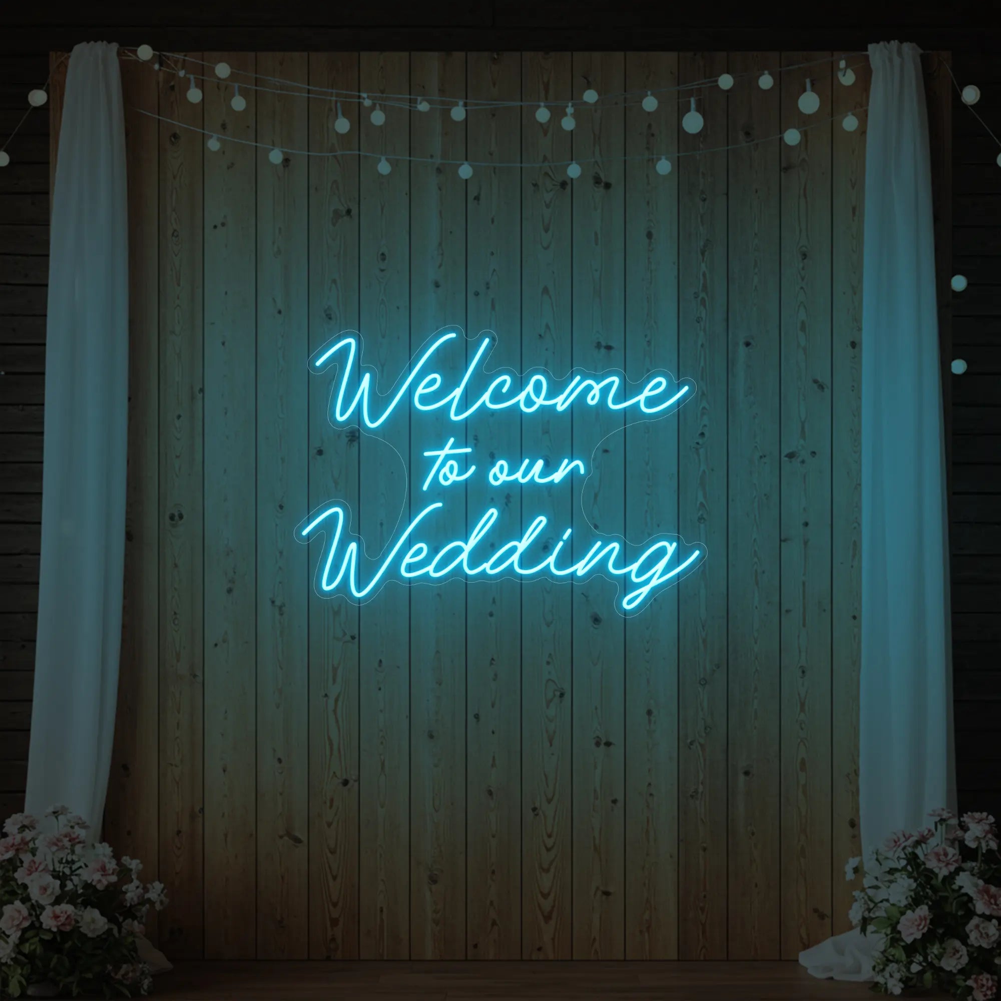 'Welcome To Our Wedding' neon sign glowing in ice blue against a styled interior wall.