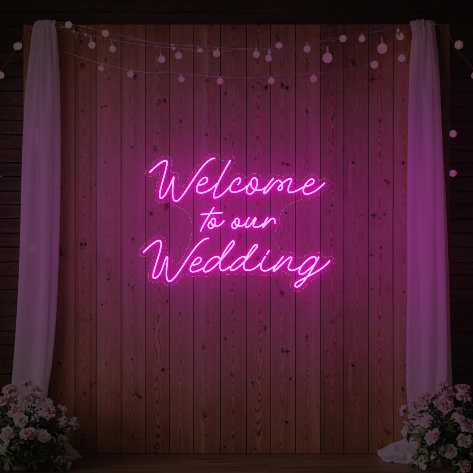 'Welcome To Our Wedding' neon sign glowing in deep pink against a styled interior wall.