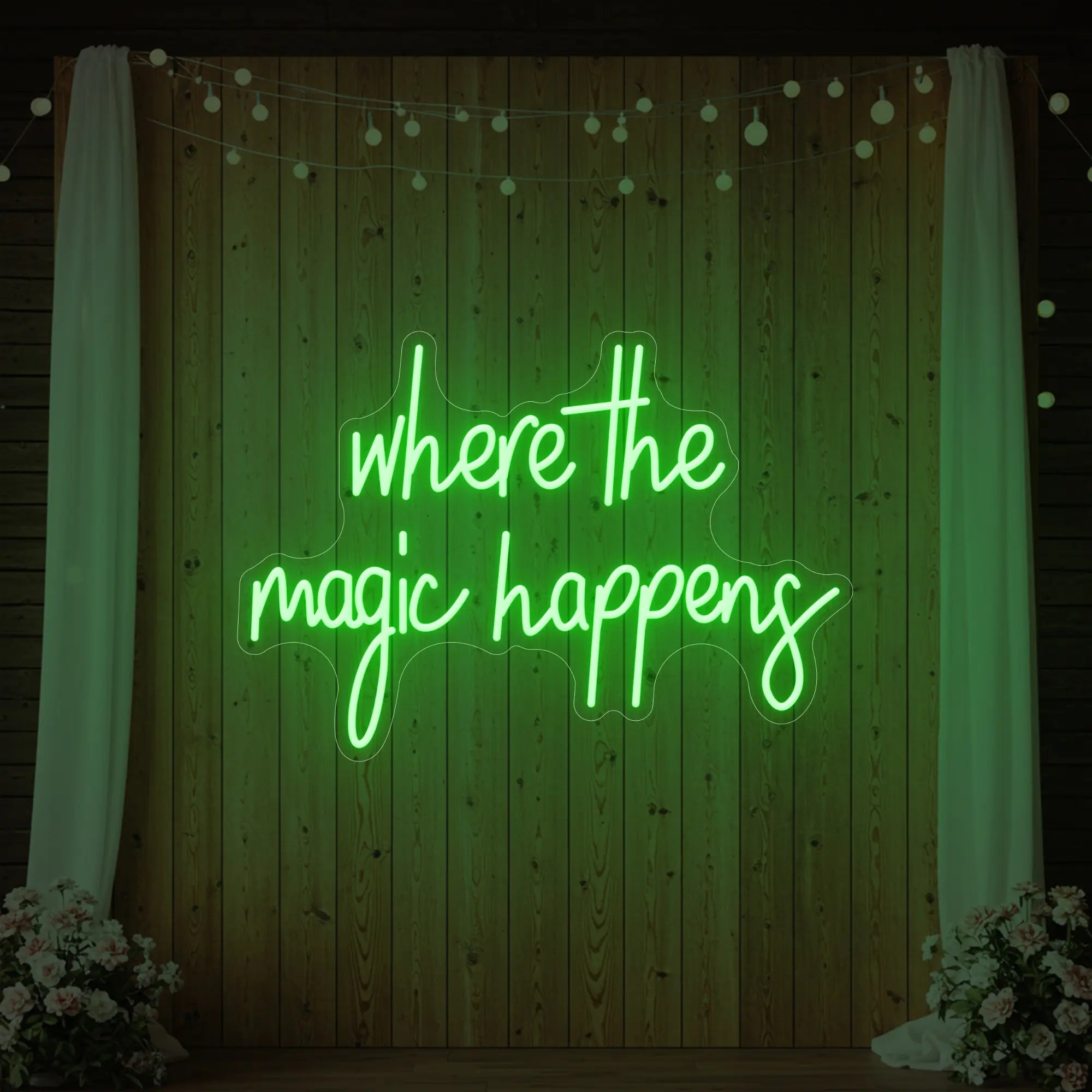 'Where The Magic Happens' neon sign glowing in green against a styled interior wall.