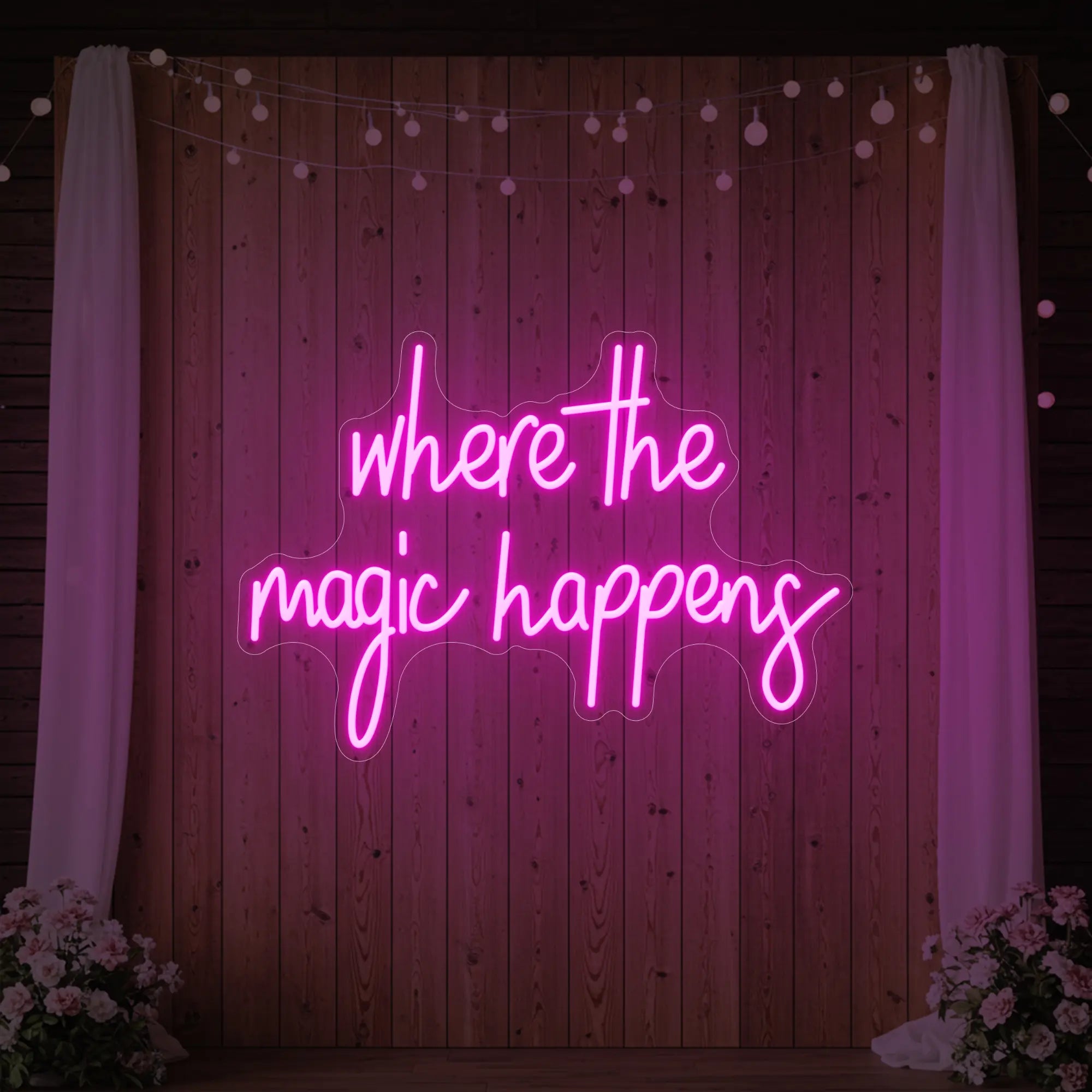 'Where The Magic Happens' neon sign glowing in light pink against a styled interior wall.