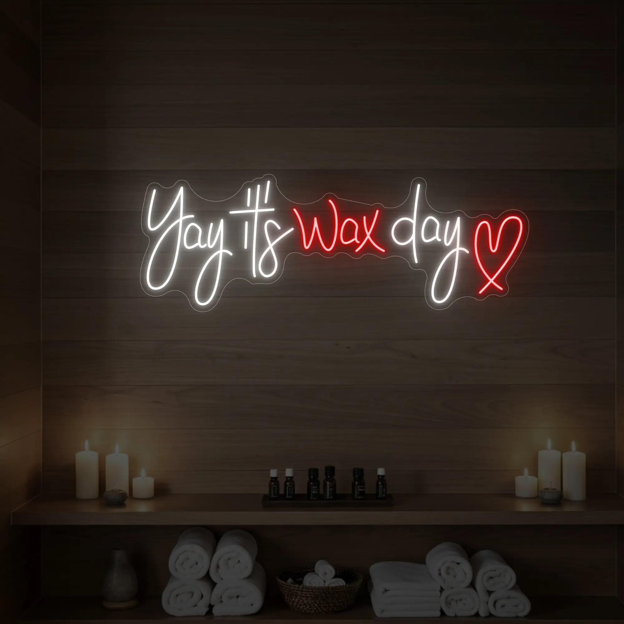 Photo of the 'Yay It’s Wax Day ❤' neon sign glowing in red against a styled interior wall.