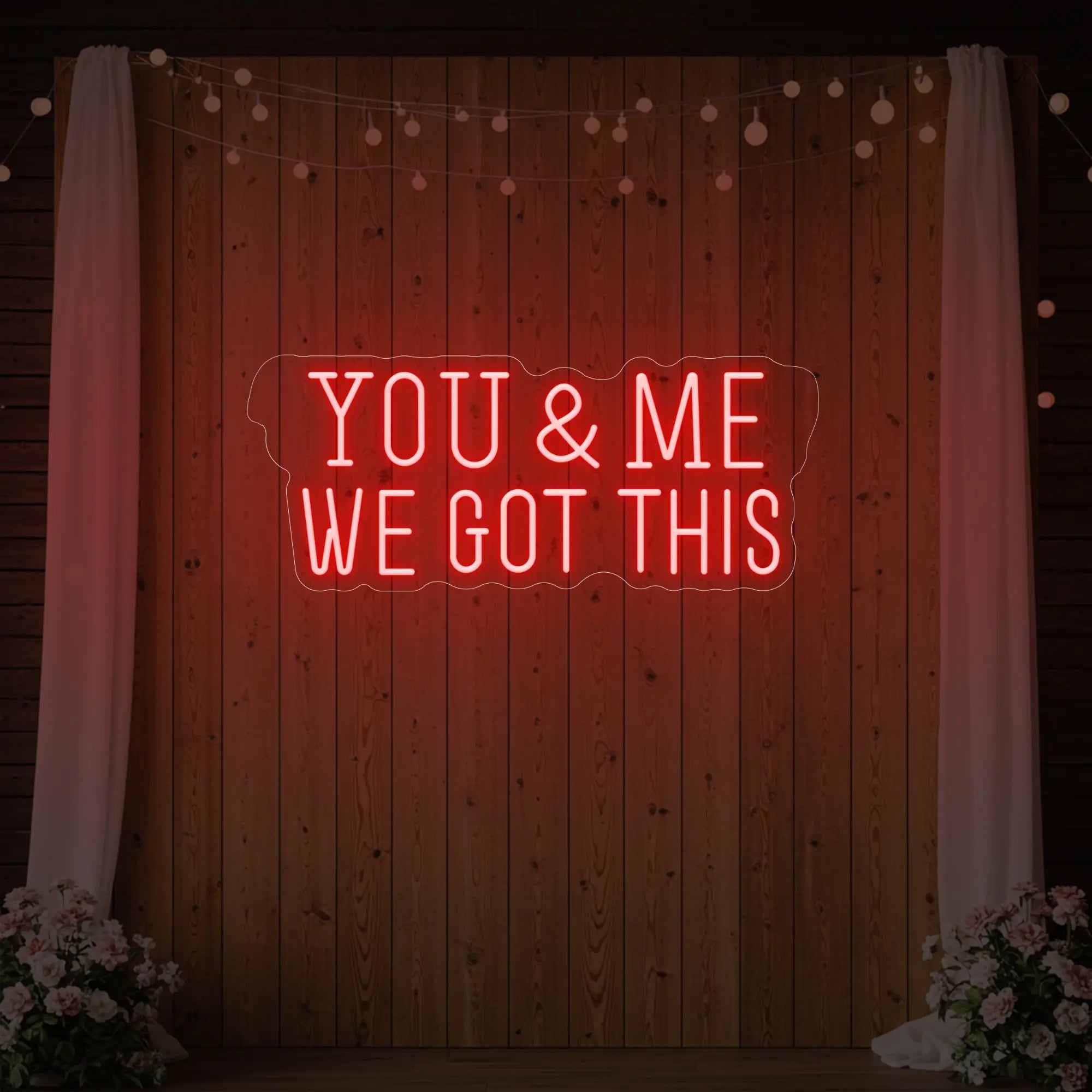 'You & Me We Got This' neon sign glowing in red against a styled interior wall.