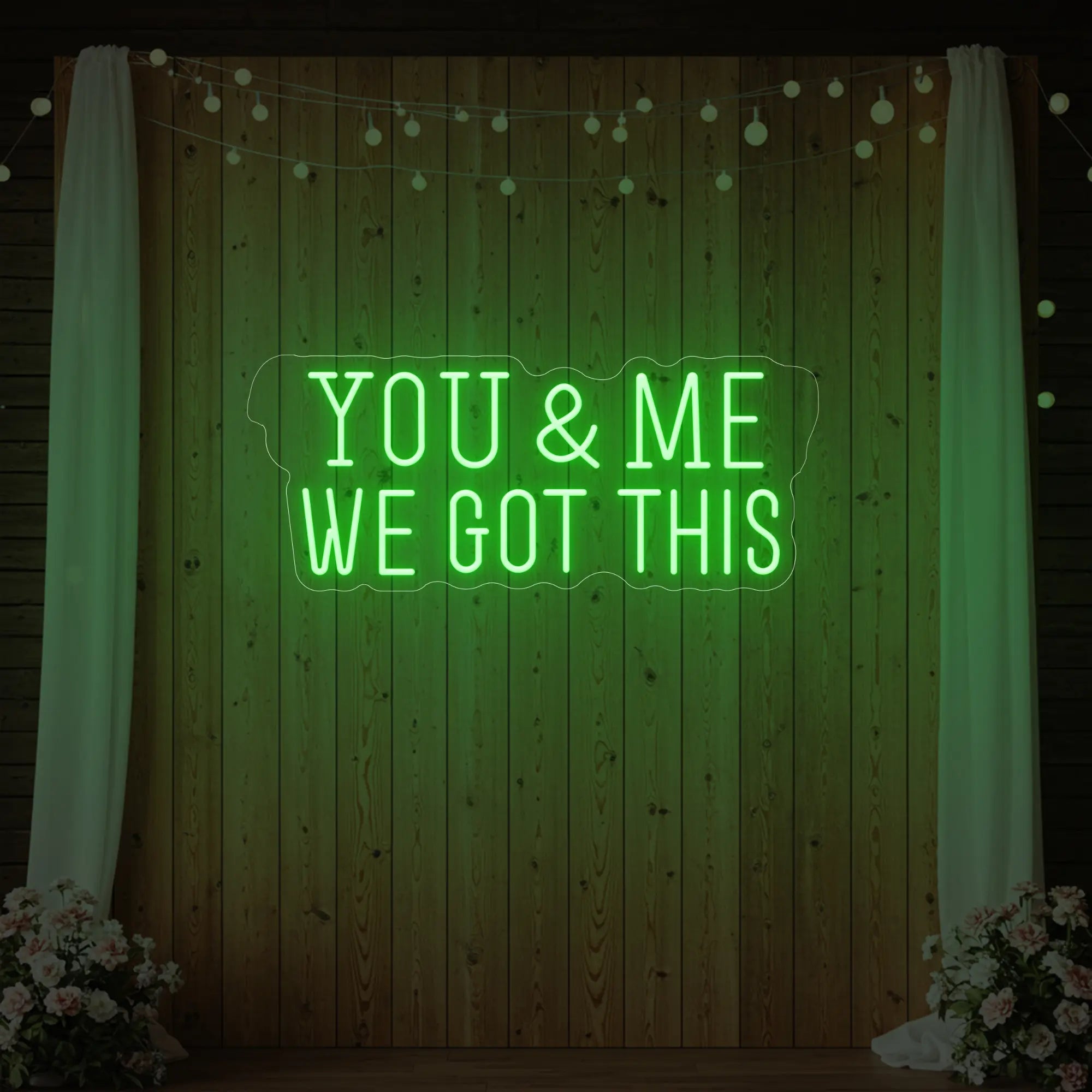 'You & Me We Got This' neon sign glowing in green against a styled interior wall.