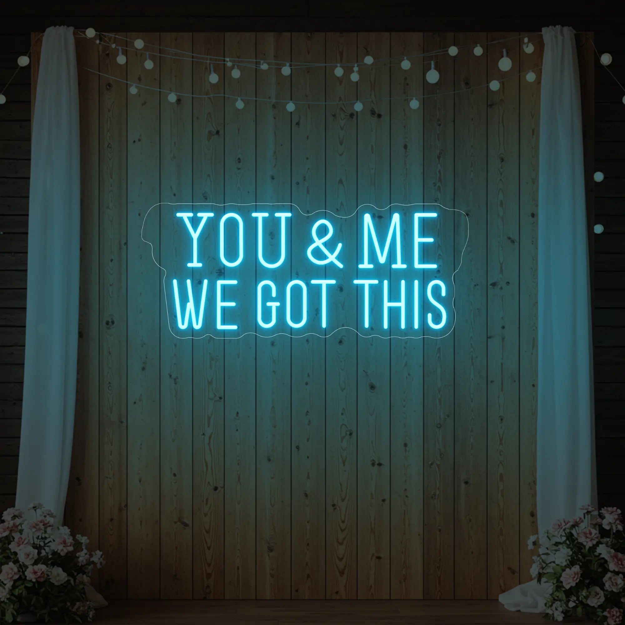 'You & Me We Got This' neon sign glowing in ice blue against a styled interior wall.