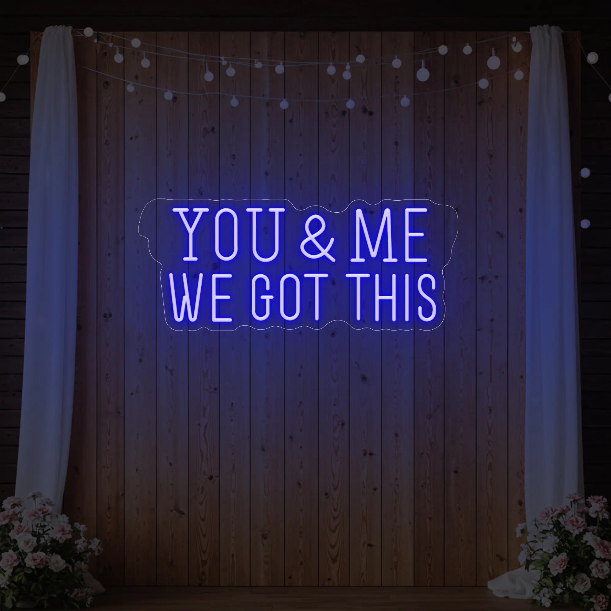 'You & Me We Got This' neon sign glowing in deep blue against a styled interior wall.