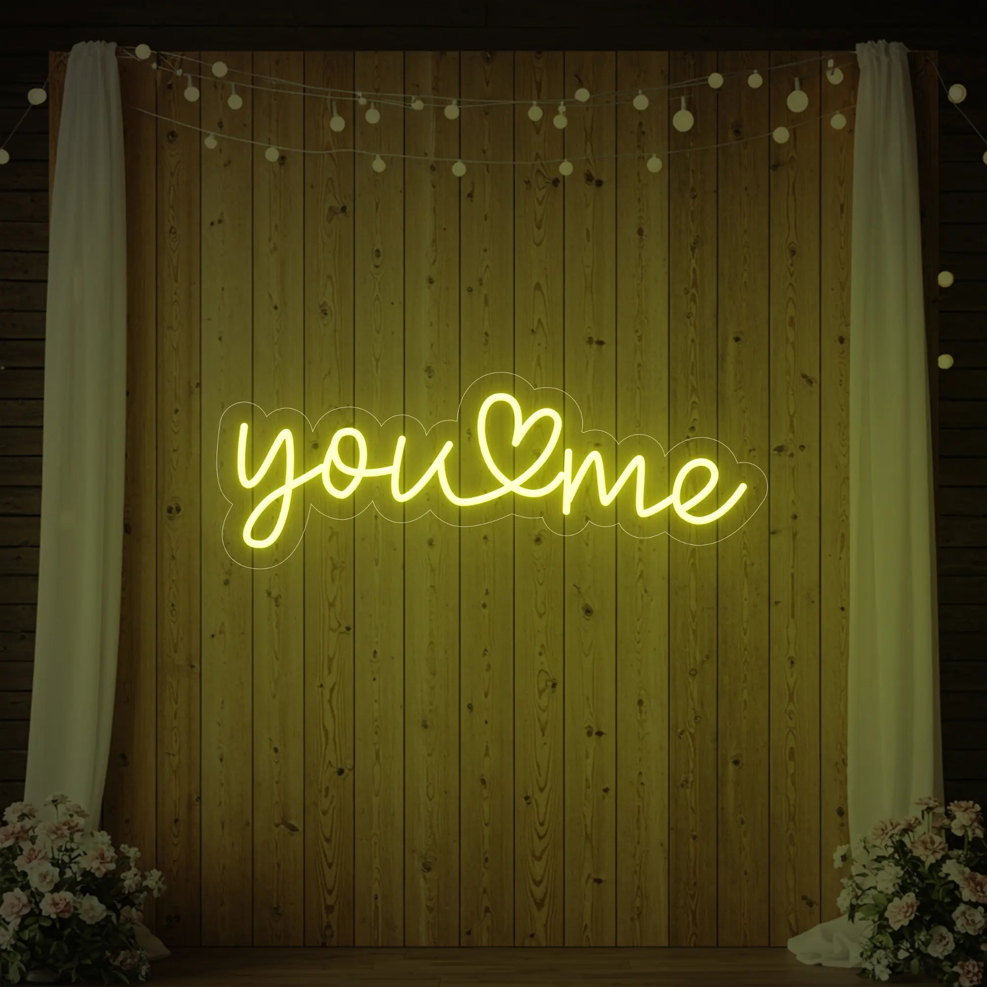 'You Heart Me' neon sign glowing in lemon yellow against a styled interior wall.