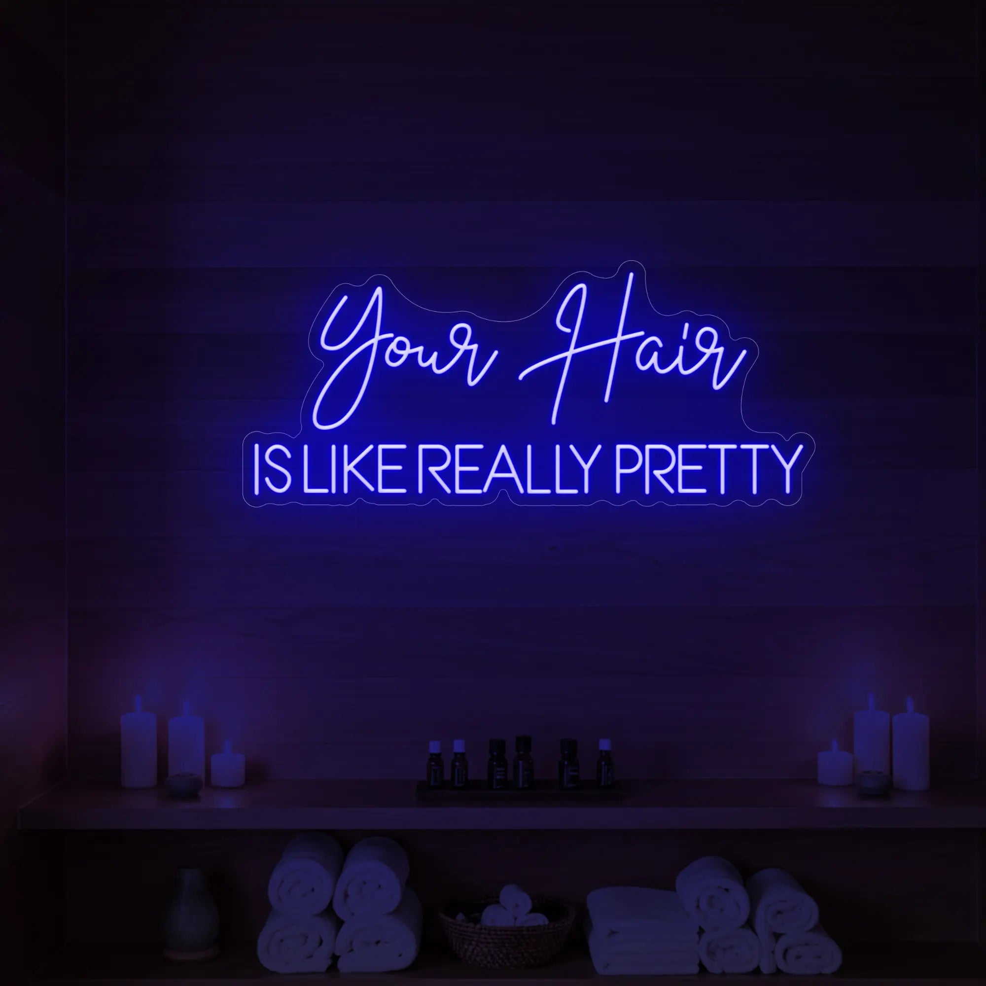 Photo of the 'Your Hair Is Like Really Pretty' neon sign glowing in deep blue against a styled interior wall.