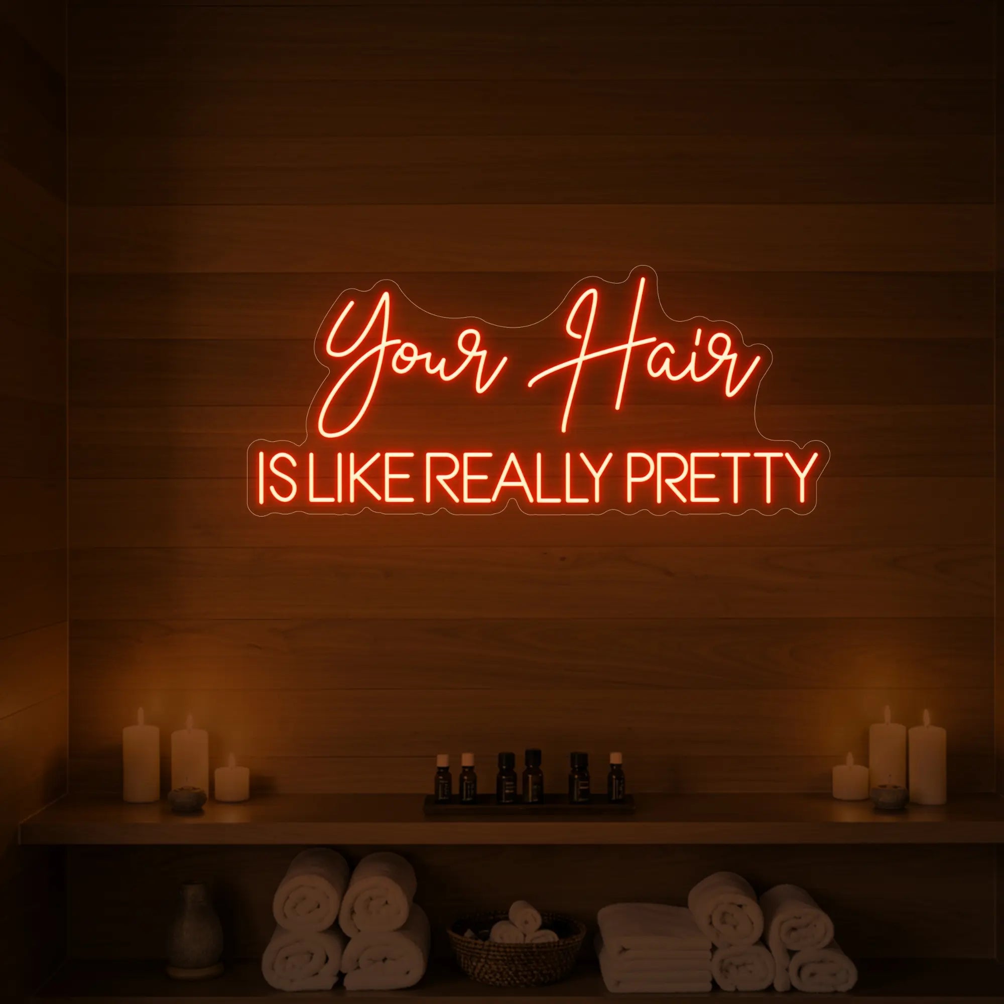 Photo of the 'Your Hair Is Like Really Pretty' neon sign glowing in golden yellow against a styled interior wall.